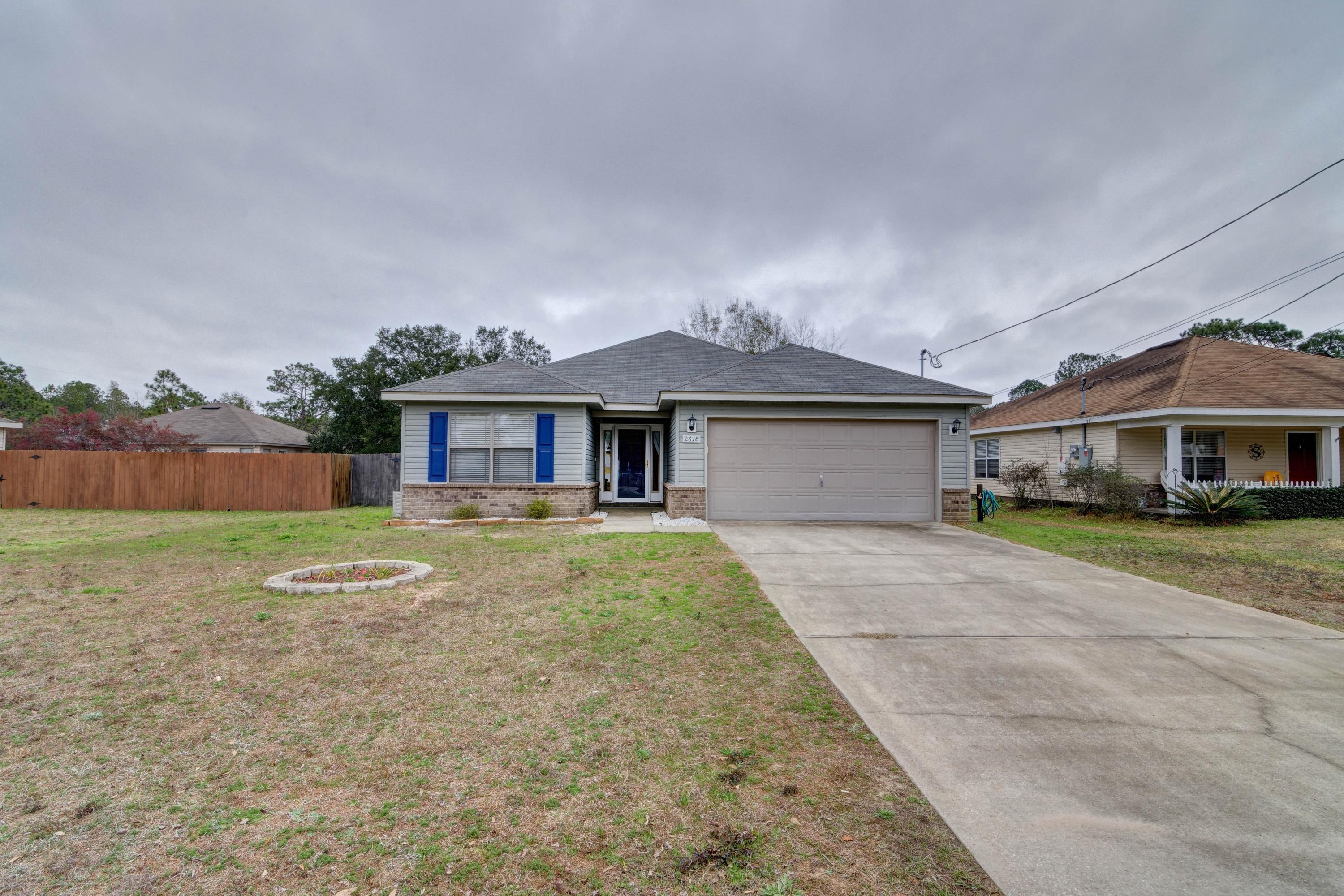 Pride of ownership shines through in this well maintained and lovingly updated 3 bed/2 bath home on a huge cleared 0.32 acre lot featuring 29 rooftop solar panels. A long driveway greets you outside, and through the storm door you'll find laminate flooring throughout the living room and hallway along with neutral painted walls. The vaulted living room ceiling creates a great open space, and the split floor plan allows each bedroom privacy. The master suite features a trey ceiling, private door to the large covered patio, double vanities with a separate linen closet, very large walk in closet, and separate water closet. The kitchen has newly painted cabinetry and updated hardware, stainless appliances, and updated light fixtures. The nice sized bedrooms share a second bathroom between them, and the interior laundry room is found off the kitchen as you enter the two car garage. Outside you'll love the massive fenced in yard with a fire pit and a playground that conveys with the home. Enjoy a fantastic location with a short commute to Hurlburt Field just minutes from Navarre's beautiful beaches, with no HOA! Inquire for more information on the solar panels.