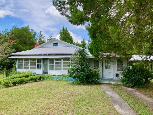 Endless Possibilities for this 1.12 acre parcel located along Hwy 90W, across the Highway from Eagle Springs Golf Course, and just one-mile from downtown DeFuniak Springs.  The property consists of an older 2000+ sq. ft. heated & cooled  home plus a large cleared and grassy lot.  Possible low impact uses in this C-1 zoning designation are: residential, professional office space, restaurant, retail store, day care center, etc. Existing home could be remodeled and put to use, or torn down for new construction.
