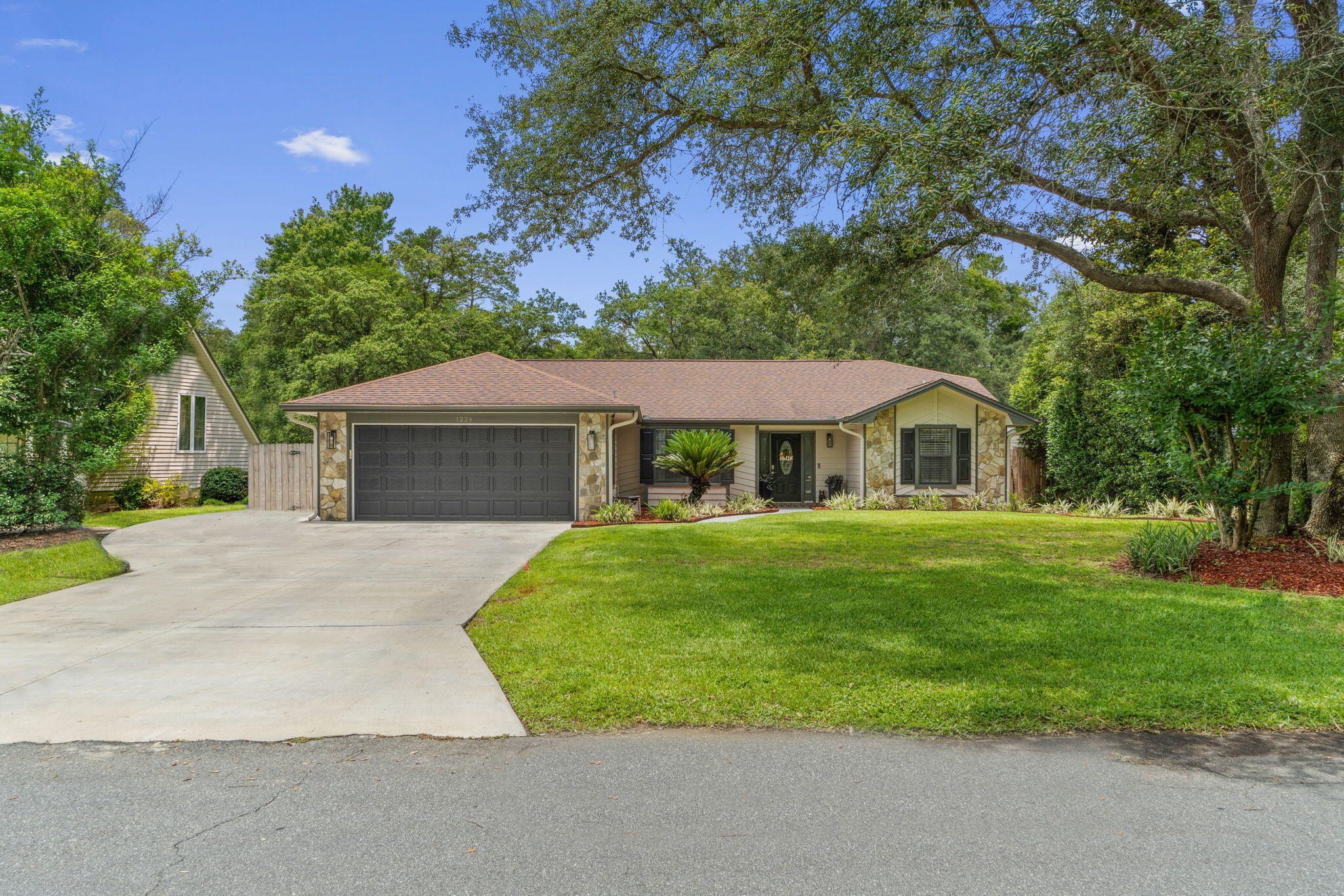 Welcome to this stunning and renovated Niceville home in the Bluewater Bay area with no HOA! With a long list of seller updates, this home nestled on 0.34 acres features 3 bedrooms, 2 baths, plus a formal dining room AND a large interior Florida room! Pull into the driveway (with an extended pad with room for your boat!) and immediately you'll see pride of ownership with the well kept and tasteful landscaping as well as the fully repainted exterior. Inside you'll find a fantastic entryway open to the spacious living room with a fantastic focal point in the custom fireplace surround. The formal dining room is a gorgeous space with plenty of room for you to spend time around the table. There is a custom barn door leading to the large interior Florida room - perfect for an additional living space, an office, playroom, etc! The well appointed kitchen has stainless appliances and granite countertops with plenty of cabinet and counter space, a wine fridge, custom shiplap, and an eat in kitchen area. There is another custom sliding door leading to the interior laundry room which features a large closet, and that leads to the two car garage. The master suite is an OASIS! With stunning accent walls you will absolutely look forward to coming home to this space every day. The sellers have fully renovated this en suite with a new walk in closet space and a fully updated owner's bathroom featuring new double vanities, tile flooring, and a stunning walk in shower! This split floor plan features two more bedrooms on the other side of the house that have had their own custom updates, as well as another fully renovated gorgeous second bathroom! As if it couldn't get better, walk outside to find a relaxing and spacious area to enjoy! The large fully fenced in backyard (the property line extends past the fence) is complemented with a large back patio with a covered pergola, mature trees, and a wonderful fire pit patio area to enjoy. The back yard is definitely large enough to accommodate a pool, but there is also access to the local Bluewater Bay pool with a membership. Conveniently located close to the award winning Bluewater Elementary, shopping, golf, Eglin Air Force Base, and 2 miles from the Mid Bay Bridge which gets you straight to Destin's beautiful emerald coast beaches, make your appointment today to preview this incredible home!