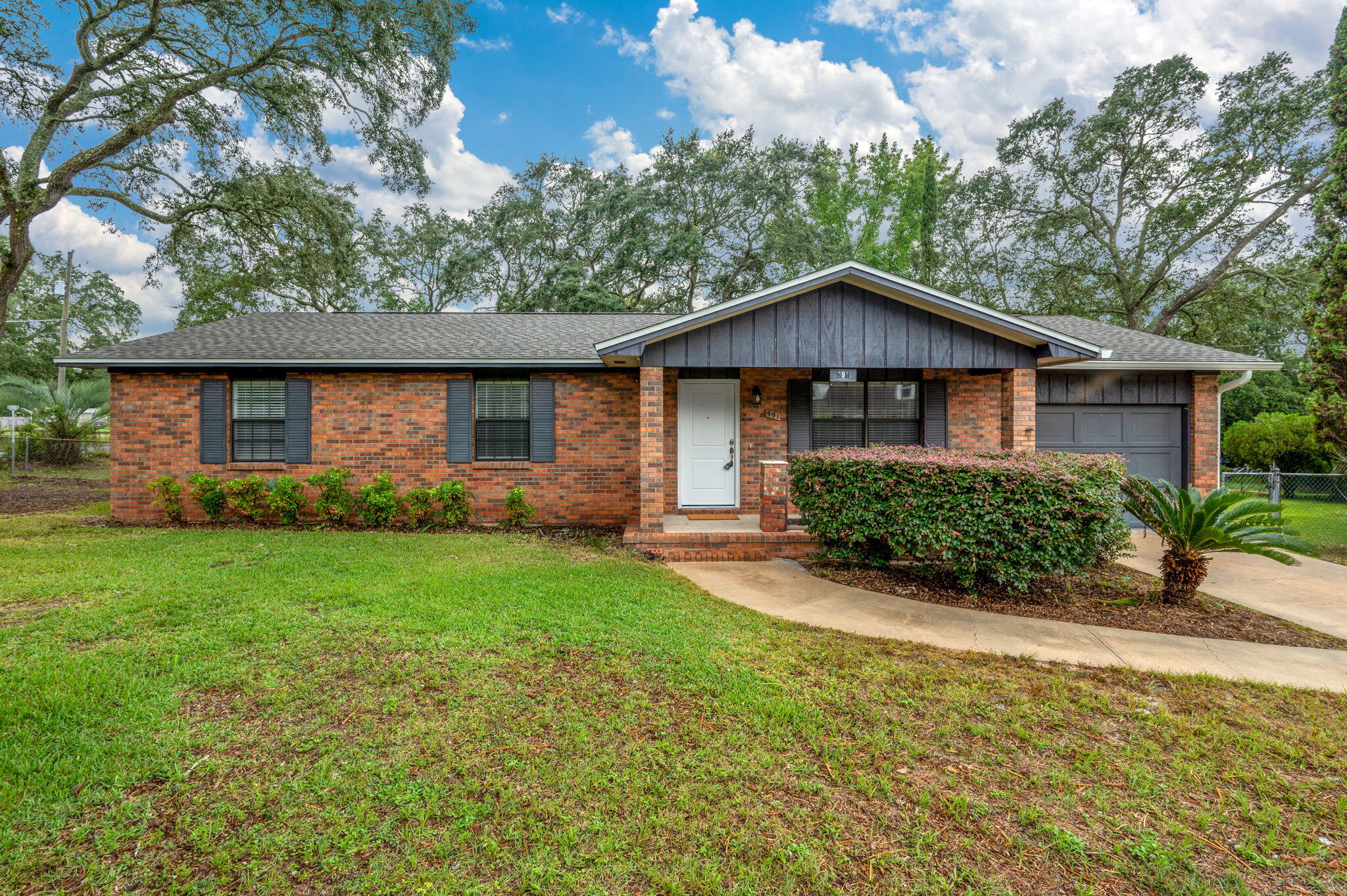 Welcome to this beautifully updated ranch-style home situated on a spacious lot in the heart of Valparaiso. With timeless curb appeal, including classic brick exterior and exterior plantation shutters, this 3-bedroom, 2-bath home offers both comfort and style. Step inside to find tasteful luxury vinyl plank flooring throughout the main living areas and a large, light-filled living room with a ceiling fan and recessed lighting. The renovated kitchen boasts upgraded cabinetry, stone countertops, stainless steel appliances, a built-in coffee bar, a quaint dine-in area, and a window above the sink that adds natural charm. A small pantry offers extra storage. All three bedrooms are newly carpeted and feature ceiling fans for added comfort. The spacious primary suite includes two closets and a private en-suite bath with a large glass-enclosed walk-in shower, single-sink vanity with stone countertop, and matching cabinetry. The guest bathroom features a bathtub-shower combo and complementary finishes. Enjoy outdoor living with a screened-in back patio overlooking the expansive backyardperfect for relaxing or entertaining. A large shed with a garage door provides extra storage or workshop space. The home also includes a single-car garage with opener, washer and dryer, and ample driveway parking.
