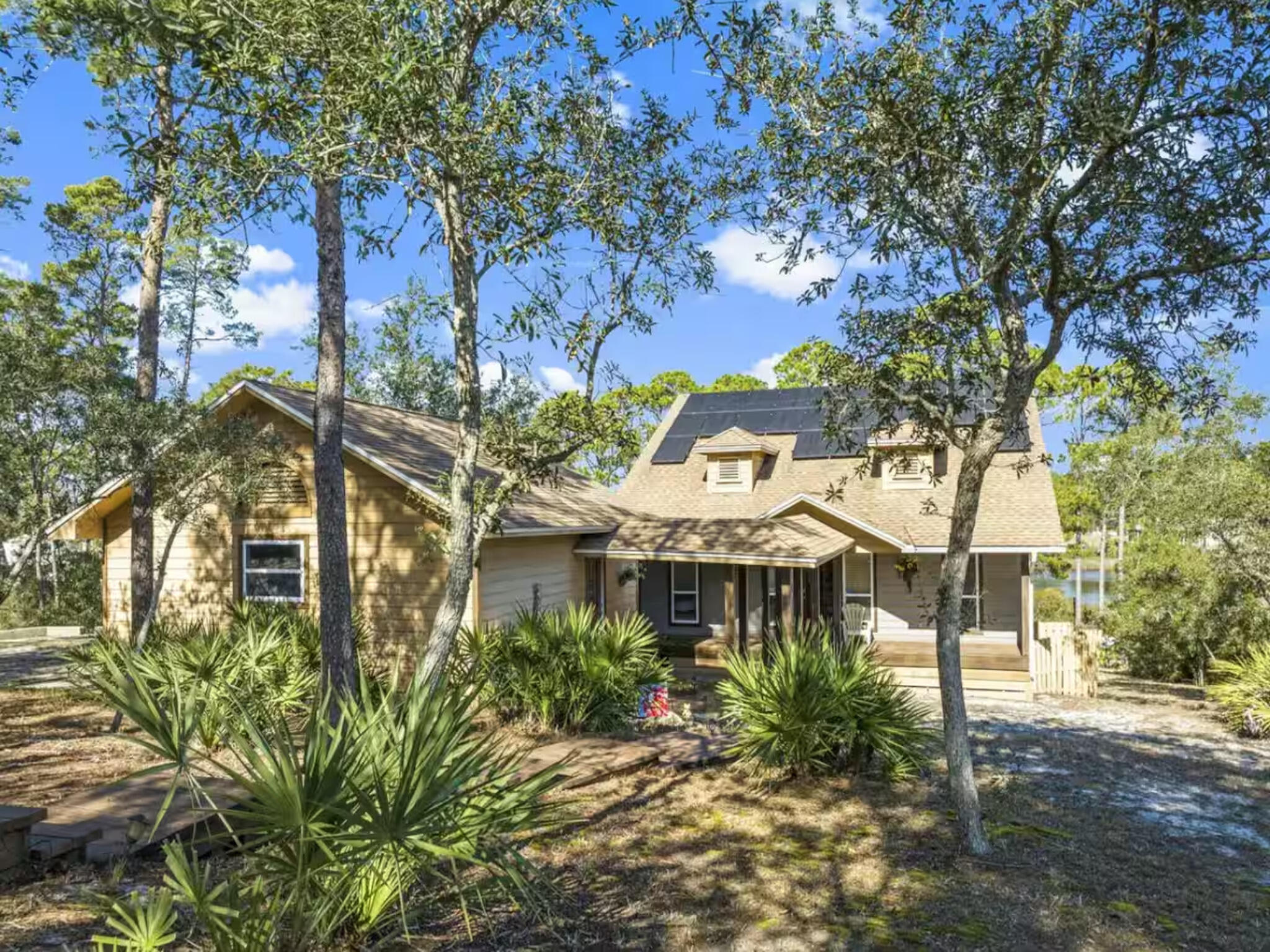 This lakefront retreat offers a rare opportunity to own over an acre of waterfront property with approximately 120 of frontage on Lake Powell, one of the Northwest Floridas iconic coastal dune lakes. Set on a 1.04 acre parcel, the property provides a sense of space and privacy that is increasingly difficult to find along the coast. The two story residence features 3 bedrooms and 2.5 bathrooms with approximately 2,176 sqft of heated living space and 3,300 sqft under roof. The layout is designed to fit both personal enjoyment and short term rental use, with living and sleeping areas positioned to take advantage of the lake setting. The main level includes two bedrooms, a full bathroom, and a living area framed by large windows overlooking the water. Upstairs, the primary serves as a private retreat with a walk in shower and separate soaking tub. A screened porch extends the living space outdoors, offering a comfortable, covered setting to enjoy lake views throughout the year. Outdoor amenities include a private dock with walkway and platform, providing direct access for boating, paddle boarding, and fishing on Lake Powell. An outdoor kitchen further enhances the waterfront lifestyle and creates an inviting space for entertaining or relaxing by the water. Located on the west end of Panama City Beach, the property is just minutes from the Gulf beaches and within close proximity of dining, shopping and costal lifestyle destinations along Scenic Highway 30A. This setting offered a balance of lakefront privacy with the convenient access to some of the areas most sought after costal amenities. No HOA