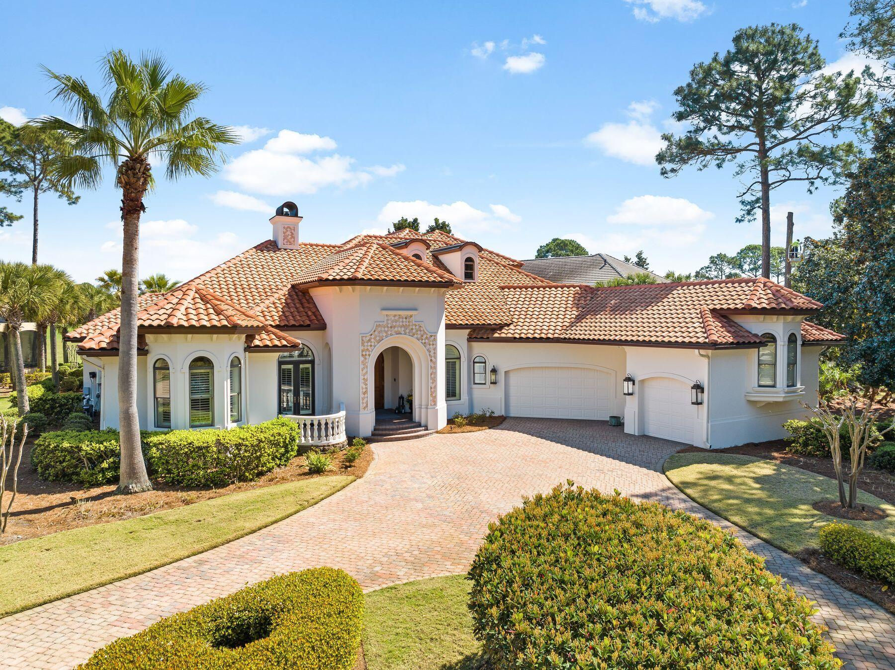 Luxury living is assured at this masterpiece residence that enjoys uninterrupted golf and lake views from the half-acre corner lot. The palatial facade marries together stone arches, mosaic stone tile, curving balconies with sturdy balustrades and a clutch of arched windows beneath the Tuscan-style roof.  A sweeping paved driveway delivers you effortlessly to the twin garage doors and imposing covered entrance. It makes a grand statement. Enjoying an unrivaled location, this prestigious residence includes multiple sitting and dining areas, a home office and garage parking for three cars. Each elegant living space is enhanced with tray ceilings, decorative custom molding, glittering chandeliers and statement lighting. Step inside to explore two sitting rooms, one designed as a family room for putting your feet up and watching TV. The second is furnished for intimate conversation in front of a cozy fireplace. A huge bowed window frames panoramic pool and golf views. The screened mansard with its curved roof encloses the sparkling pool, spa, firepit and tinkling water feature. Relax on lounge chairs and enjoy uninterrupted golf and lake views from the sunny terrace. Added in 2022, the covered outdoor kitchen has a cluster of branded stainless appliances, including a sink, refrigerator and grill, all within sight of the wall-mounted TV so you never miss a moment. The remodeled chef's kitchen includes multiple custom cabinets topped with acres of gleaming Taj Mahal quartzite. It has everything a chef could dream of, including top-of-the-range appliances and a center island. The curving bar seats four for cocktails and canapes after a round of golf with like-minded friends and neighbors. There's an additional breakfast area, two wet bars for entertaining and a formal dining area for hosting dinner parties.  This elegant home boasts four magnificent bedrooms crowned by a spacious first-floor master suite with fully retracting glass doors provide seamless access to the pool for a peaceful morning dip. The incredible master bathroom is a temple to modernity, with a jaw-dropping curved-wall shower with Waterford etched glass. Taj Mahal quartzite countertops and a jetted soaking tub are finished with mosaic tile in neutral tones. The bunk room goes the extra mile with a computer desk and space for arcade games, as well as four bunks. The second floor includes an elegant porch that is perfect for enjoying quiet moments of contemplation while savoring crimson sunsets over the lake. This immaculate home has numerous updates, including tankless water heaters, new gutters, exterior fans and lighting. Located within the exclusive enclave of Burnt Pine at Sandestin Golf and Beach Resort, owners of this magnificent residence can enjoy a host of activities, including four world-class golf courses, a multi-court tennis center, pickleball courts and optional membership to Sandestin Beach Club and Burnt Pine Country Club. Berth your boat in Baytowne Marina and enjoy endless watersports on the bay. Boutique shopping and gourmet dining abound in the Village of Baytowne Wharf, Grand Boulevard and Market Shops. All this and more are just a golf cart ride from the door.