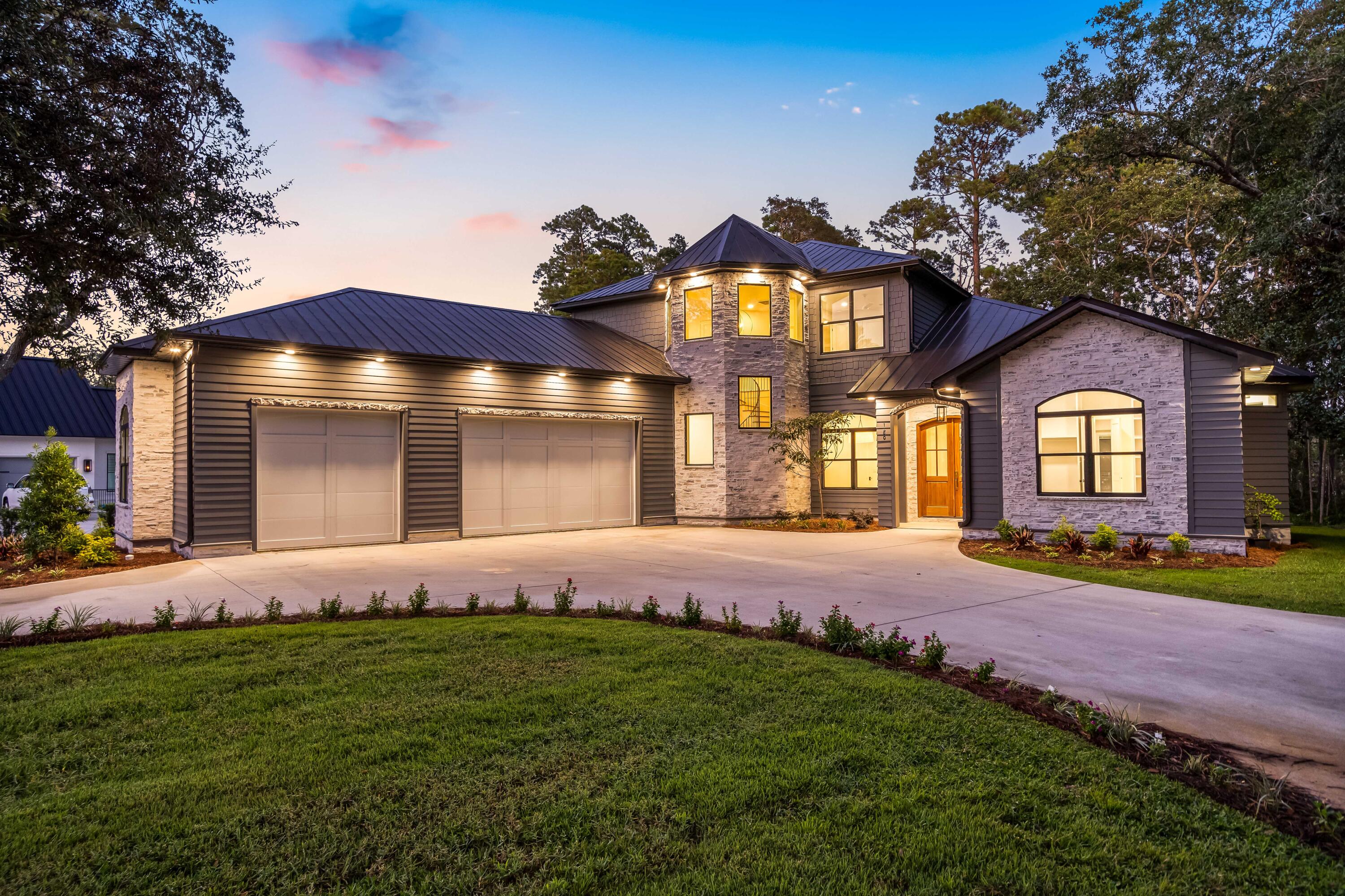 Introducing 180 Grand Flora Way, a brand new waterfront residence in the prestigious Botany Bay Subdivision of Santa Rosa Beach, Florida. The 5-bedroom home offers 3,657sf of living with over 5000sf under roof including the garage and the outdoor patio area. Inside the gates of Botany Bayou you'll find a mature neighborhood of local renown with majestic oaks lingering endlessly. Upon arrival step through the custom Mahogany French doors adorned with brass Emtek handle set and be greeted by the warm glow of a gas lantern, a preview of the elegance that lies within. As you enter, you'll be embraced by the timeless beauty of engineered hardwood flooring that stretches throughout the home, creating a seamless flow from room to room. The foyer beckons with continuous vertical shiplap that extends floor to ceiling, setting the tone for the exquisite craftsmanship found throughout.

The master suite exudes luxury with marble mosaic floors and dolomite shower walls. A custom double vanity and storage towers provide convenience and style, topped with a marble counter. Kohler plumbing fixtures, including digitally controlled shower heads, a rainhead, and handheld in the walkthrough shower, offer personalized luxury. The custom built-in closet features a marble-topped vanity table. Doors lead outside to the marble-paved porch, where a bronze outdoor shower awaits.

The outdoor patio boasts an inviting atmosphere for outdoor living. The outdoor kitchen is a culinary paradise with a 32-inch four-burner gas grill, undercounter refrigerator, pull-out trash bin, stainless steel storage drawers, doors, sink, and faucet. A quartz countertop adds elegance. An outlet for a TV, a 48-inch concrete gas firepit, and comprehensive lawn irrigation complete the outdoor oasis.

The office space / bedroom boasts a hidden closet discreetly tucked behind a built-in bookshelf, offering both style and practicality.

The living room is adorned with Visual Comfort brass picture lights, accentuating the custom cast fireplace surround by DreamCast.

The large sliding doors connect the indoors with the outdoors, creating a harmonious blend of spaces.

The heart of the home, the kitchen, is a chef's dream. Painted and white oak custom cabinets provide ample storage, while the 11-foot island becomes a gathering place.

Leathered Taj Mahal Quartzite countertops and backsplash exude luxury, perfectly complemented by brass and seeded glass island pendants. A 48-inch Dacor professional gas range, Dacor panel front freezer and refrigerator, and Bosch panel front dishwasher offer top-tier functionality. The 45-inch undermount workstation sink with a natural stone apron front is both functional and stylish, accompanied by a Newport Brass unlacquered brass faucet.

The butler's pantry is a treasure trove of convenience, featuring floor-to-ceiling custom cabinets, a Dacor dual-temperature wine refrigerator, and panel front KitchenAid icemaker and refrigerator drawers. Brass and glass pendants by Generation Lighting illuminate LED-lit shelves and glass cabinets.

The laundry room is designed for efficiency with custom cabinets built to accommodate a full-size stacked washer/dryer, a laundry chute from the second floor, a sink, and a Brizo faucet in a LuxSteel finish. Quartz countertops add a touch of modern to this functional space.

The powder bath boasts marble mosaic tiles and a custom reeded floating vanity with a concrete vessel sink and marble countertop.

In the three-car garage, practicality meets luxury with a dog bath, utility sink, and ample space for storage.

Ascend the custom steel handrail by Saltwater Steel in the stairwell, accompanied by custom-built and stained stair treads. A beautiful antique gold chandelier adds a just the right touch to a true staple area within the home.

The landing upstairs provides additional storage in a built-in shelved closet, a laundry chute, and extra unconditioned storage space above the garage.

Guest bathrooms upstairs are adorned with marble mosaic tile floors, custom painted vanities, and lighting by Visual Comfort. Quartz countertops complete the picture of refinement.

Guest bedroom #1 features an ensuite bath with a walk-in shower adorned with glass doors and a spacious custom built-in closet.

Guest bedrooms #2 and #3 share a bath boasting a custom double vanity and a bath tub with glass doors. Built-in closets offer organized storage solutions.

A large upstairs den/media room provides versatile space for relaxation and entertainment.

The new owner of this home will have the opportunity to finish out the dock of their dreams to accommodate watercraft of their liking. A standard dock was previously permitted but the seller has decided to allow the next purchaser to build what they prefer rather than settling for a simple design. Some pilings are already in place and others are already on-site and ready to be placed upon new design and approval.

The landscaping surrounding the residence completes the picture of coastal luxury. Flower beds showcase Eagleston Hollies, Sunshine Ligustrum, Sun Hostas, and Triostar Stromanthe. The bed at the front door features a Loquat tree, Loropetalum, and Agapanthus. The mailbox area is a symphony of Asiatic jasmine vine and Podocarpus, creating a warm welcome for residents and guests alike.

180 Grand Flora Way encapsulates the essence of sophisticated coastal living, inviting you to indulge in a lifestyle of luxury and comfort. Explore this exceptional property in the exclusive Botany Bay Subdivision and experience the epitome of Santa Rosa Beach living.