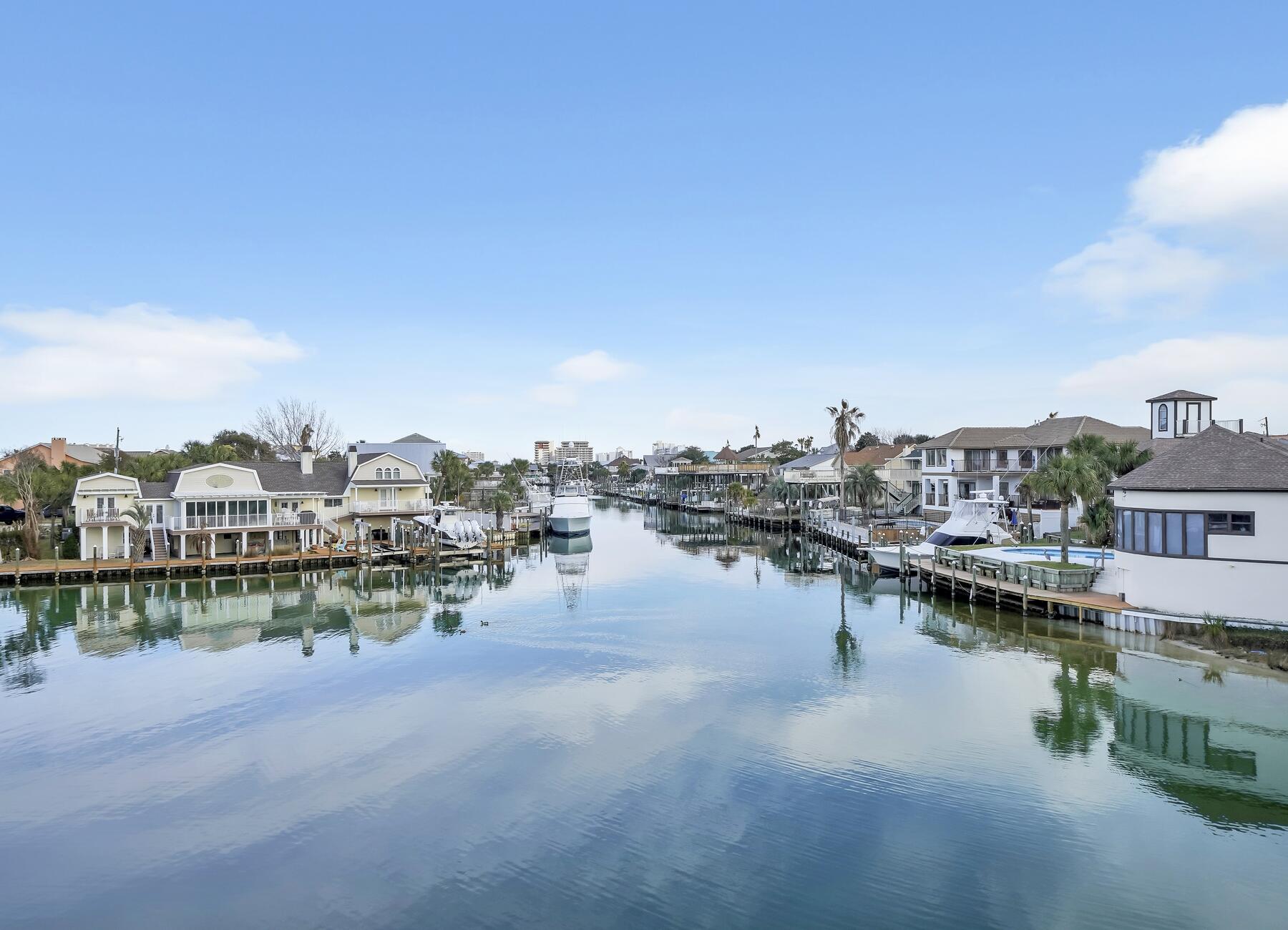 Beach Lovers & Boaters Dream Come True! Paradise Awaits at this Exceptional Waterfront Property with 2 Covered Boat Lifts AND Only a Few Minutes Stroll to The Beach! This Stunning, Fully Remodeled Townhome Has So Many Unique Attributes! Your Extra-Large Sun Deck Out Over the Canal offers Superb Sunrises, Plenty Of Space to Sit and Enjoy Your Coffee in the Mornings, Afternoon Sunbathing, or Chill with a Glass of Wine Under the Lanai in the Evenings Outside Watching TV Or Sitting Around Your Cozy Deck Glass Fire Pit. Brand New Hot Tub Installed This Year; Soak Under the Stars and Sip on Some Sangria! The Bottom Level Boasts a Full Custom-Built Wet Bar Featuring An Eclectic Copper Sink, Pecky Wood Cypress Live Edge Countertop and built in Wine Cooler, Beverage Cooler and Ice Machine. Second Living/Movie Room could be turned into a Game Room for Entertaining or To Boost Those Rental Numbers! 2 Bedrooms with 2 Private Bathrooms Complete the Bottom Level. Upstairs Your Eyes Will Be Drawn Immediately to That Expansive Deck with Beautiful Water Views Until You Catch a Glimpse of The Complete Custom Kitchen/Dining Area Featuring an 8' Butcher Block Island, Large Barn Door Style Pantry, Stainless Appliances and The Most Gorgeous Granite You Have Ever Seen! The Cozy Master Suite Encompasses the Rest of This Top Level. Additional Highlights this Property has to Offer Include, Private Beach Accesses Within Easy Walking/Biking/or Golf Cart Ride Distance. Less Than 15 Minutes by Boat to the Destin Pass, Gulf of Mexico and Famous Crab Island. 2 Deep Water Slips with an 8k lbs. Lift and a 10k lb Lift Situated at the Widest Part of the Canal for Easy Turning and Docking! Kayak, Jet Ski, Paddle Board, Fish, Swim, or Take the Water Taxi, ALL from YOUR Back Dock! Large, Maintenance Free, Fenced In Private Side Yard Perfect for Gardening Lovers or Space to Let Your Dogs Run Free. Too Many Upgrades and Features to List Them All, Please See Document Section for More Details! Townhome Being Sold Mostly Furnished, Exclusion List will be Provided. There is Nothing Else Like This Unique Townhome Currently on the Destin Market So Don't Miss This Opportunity to Own Affordable Waterfront Today!