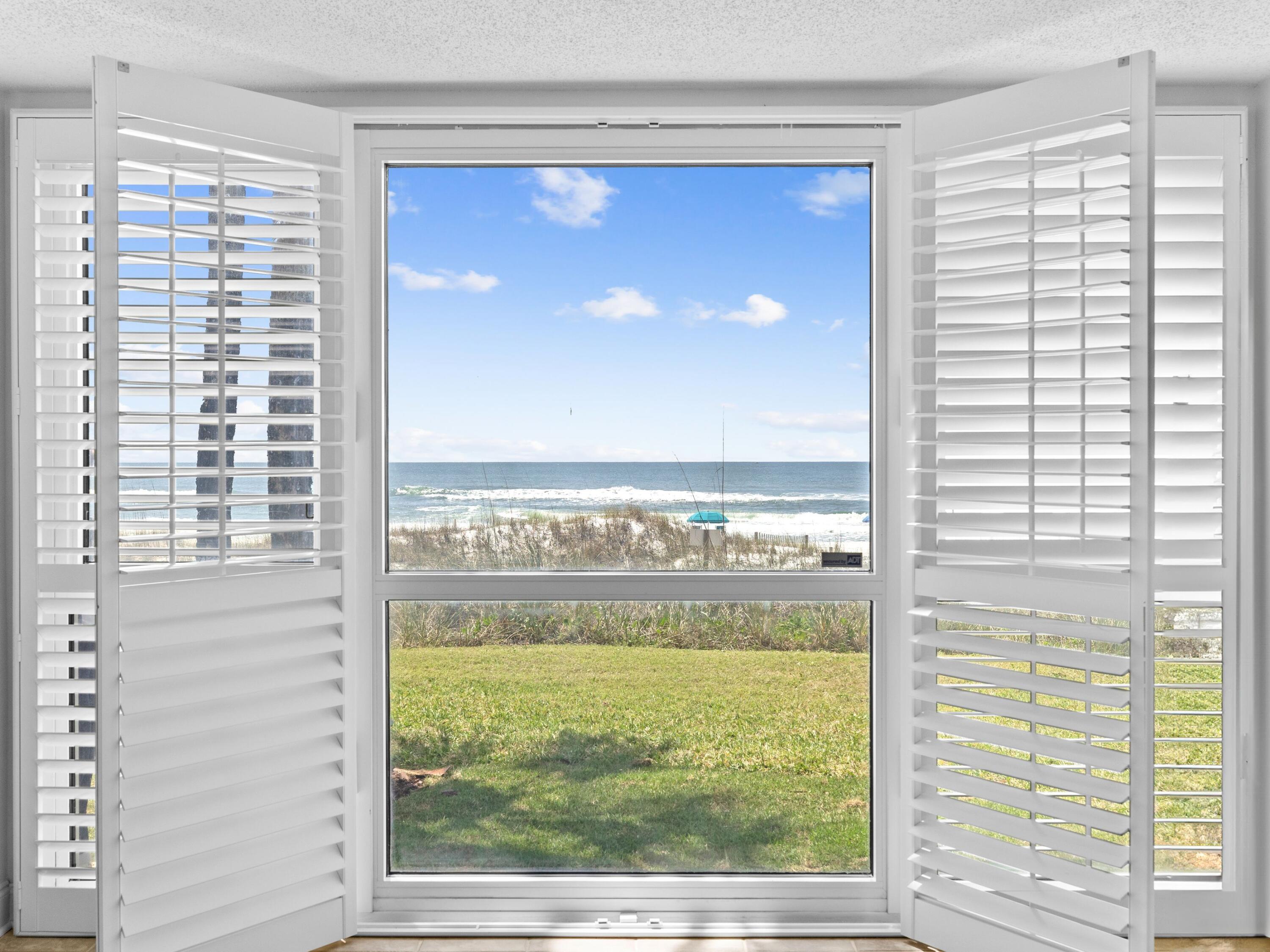 Step into your coastal paradise with this ground-floor condo, perfectly situated in the heart of Destin. Enjoy the convenience of parking right outside your door—no elevators needed! As you enter, you are greeted by breathtaking Gulf views from the living room, kitchen, and primary bedroom. The open kitchen is both spacious and equipped with stainless steel appliances, complemented by granite countertops that offer ample workspace. The high-top breakfast bar is perfect for casual dining, while a pantry and storage closet provide additional convenience. A designated area accommodates a full-size washer and dryer, making laundry a breeze. Tile floors and fresh paint enhance the generous dining and living areas, which come partially furnished for your comfort. Sliding doors lead to a covered patio where you can unwind and soak in the soothing sounds of the waves, all while enjoying unobstructed views of the pristine white sandy beach. The community pool and beach walkover are just steps away, ensuring easy access to sun and surf. Retreat to the primary bathroom featuring a newly installed quartz-topped vanity and a shower-tub combo. An additional bedroom and second bathroom are conveniently located down the hall, perfect for guests. Plantation shutters and hurricane shutters offer added privacy and peace of mind when you're away. Located in the gated community of Grand Mariner, this Gulf-front residence boasts 375 feet of soft white sand for your toes to sink into. With a minimum 90-day rental policy, this condo ensures a serene living environment while still being close to all the shopping, dining, and cultural attractions that Destin has to offer.