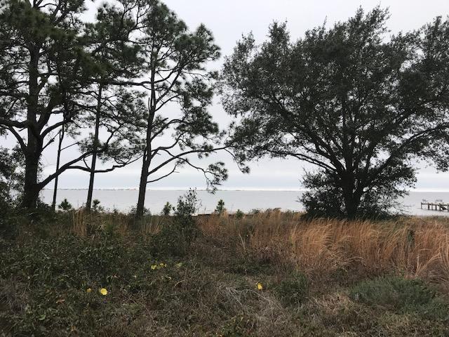 Waterfront lot, unparalleled views of Santa Rosa Island, incredible sunrises and sunsets, fantastic fishing, boating, all on the spectacular Sound. Located on a quiet cul-de-sac, this upscale waterfront community features a beautifully landscaped entrance, curbs and sidewalks, pool, underground utilities including sewer (not septic), natural gas available, common park located directly on the Sound, nature walk, pier and seawall, and over 13 acres of conservation/preservation area. Lot has an existing seawall and has a few tall pines and some oaks. Least expensive waterfront lot for sale in Sound Hammock. Buyer to verify all pertinent information.