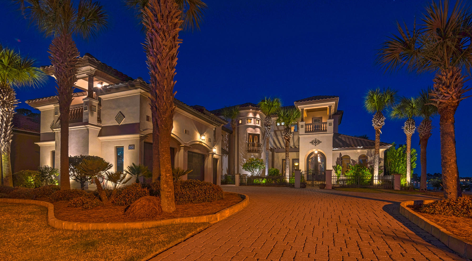 Mediterranean design complemented by Old World elegance will instantly grab your attention in this beautiful waterfront residence. Upon entering, you are greeted by breathtaking 11 foot iron doors. As you pass through the archway into the foyer, you will then embrace the shimmering water of Grand Lagoon. This home blends rustic comfort with casual elegance. Design elements of travertine, stone, copper, tile, wood and mosaics, Corinthian columns and coffered ceilings are artfully orchestrated throughout the home. To your right as you enter is the guest suite which includes a walk thru closet and bath with a steam shower- the vanity is a sacrament piece from a historic church, and an exercise room overlooking the lagoon. The living room includes a double side fireplace, which graces the living room and family room, a custom bar with a copper top, a finished wine cellar and built in cabinetry including a 19th Century ships door. Reclaimed from Lake Michigan, wide plank Heart pine floors and Old Chicago brick archways take you into the heart of this home which also includes the incredible view of Grand Lagoon. The kitchen boasts all of the essentials to preparing a gourmet meal. The dining room and family room also overlook the backyard, lagoon, pool and hot tub. The family room comes complete with a built in entertainment center and computer desk. The outdoor kitchen will be a chef's dream, featuring a custom made wood burning and gas brick oven, professional gas grill and granite countertops. Continuing up the wrought-iron staircase to the next level, you will enter the media/bonus room over the 3-car garage. The bonus room includes a full bath with shower, built-in media center, wet bar, 2 bunk rooms, and room for a pool table (included). Walking up to the next level of the home you will pass the Juliette balcony overlooking the front yard. On the left is a large laundry/craft room with built in cabinets and granite counter tops. Down a slightly elevated hallway on your right are 2 additional bedrooms with full baths and walk in closets, each room featuring its own balcony. At the back of the home overlooking Grand Lagoon is an executive office with a two-sided desk and custom cabinetry. The master suite is adjacent and includes a large bedroom with a tray ceiling, balcony shared with the office, and a sitting area overlooking the spectacular view of Grand Lagoon. The master bath includes double raised sinks, Jacuzzi tub, open dual shower, and walk in closet with custom cabinetry and a hidden door to the laundry room. The home also includes a 3-car garage with a workshop.The dock includes boat slip and boat lift. This mediterranean interpretation of Old World design makes the home a lovely and unique example of Florida coastal living. All info is approximate please verify if it is important.