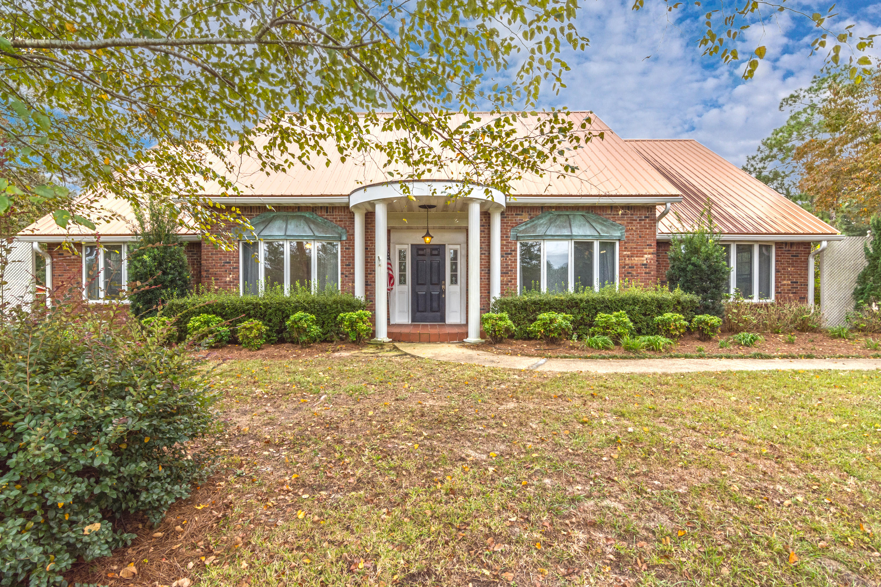 Location dream home! County setting near shopping schools and banks! Copper roof, patina copper accents all Brick Massive oaks, Dogwoods, and Magnolias abounding in golden sun rays surrounded by fenced and cross fenced pasture! This home has tile floors, metal roof, fire place lots of large windows and an attached two car garage. Located on nearly six pasture grass acres with a three stall horse barn with a Tac room, and a Chicken coup ( converted to a sitting room). Come home to 5869 Hillcrest Drive today!