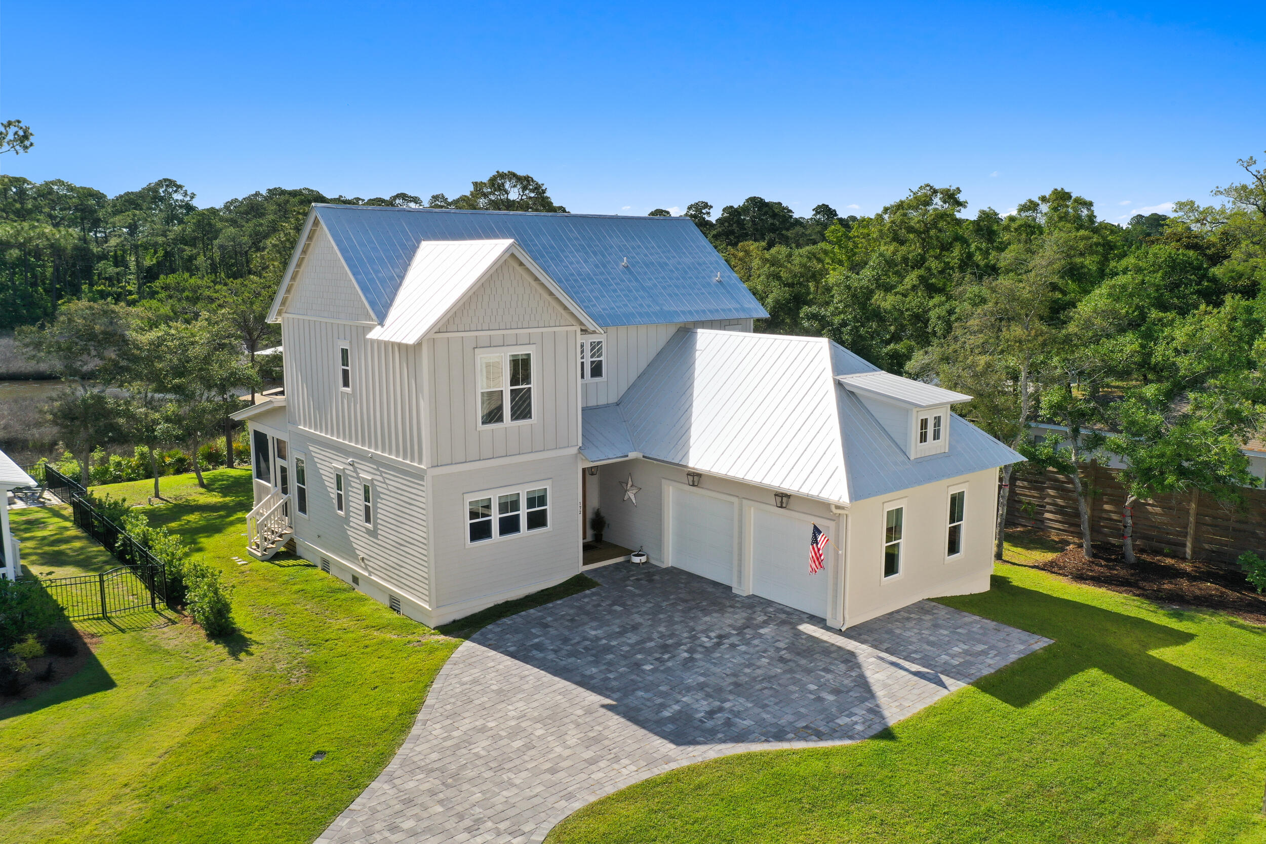 Welcome to this beautiful waterfront home located on an oversized corner lot with maximum curb appeal in a fantastic development! Constructed by Paradise Coastal Builders in 2021, this large, 4 Bed, 4.5 bath, two-story residence is the perfect family home, thoughtfully designed with style, functionality, and the SoWal lifestyle in mind. The property boasts breathtaking views of Musset Bayou and Choctawhatchee Bay from nearly every room, making it an ideal place to call home and create unforgettable memories. Step inside and be welcomed by a gourmet kitchen featuring KitchenAid appliances, quartz countertops & backsplash, pot filler, farm sink, and custom hood vent & cabinetry. The oversized kitchen island is a great centerpiece and gathering spot, perfect for hosting a dinner party or enjoying a casual meal with loved ones. The butler's pantry adjacent to the kitchen offers additional but separate space for dinner prep and appliance storage, includes a second undermount sink and custom cabinetry. The living room features a gas fireplace with a pecky cypress mantel, framed by built-in bookshelves, making it the perfect spot to cozy up with a book, spend time with family, or entertain guests. The main master suite is waterfront and features vaulted ceilings that create a special and relaxing space. The ensuite bath features a walk-in shower with bench, separate soaking tub, double vanities, and a private water closet. An ample walk-in closet off of the master bedroom has built-in shelving. The downstairs master suite is perfect for guests and family, featuring its own ensuite bath with walk-in shower with bench, double vanity, private water closet, and large closet with built-in shelving. Both master suites have access to their own porches, overlooking the classic and timeless coastal bayou scene; sawgrass, live oak trees, spanish moss, and longleaf pine trees. Upstairs, you'll find the third and fourth bedrooms, each with their own private bathrooms. The full laundry room downstairs features a dog wash and additional cabinetry above the washer and dryer, offering excellent convenience. Thoughtful extra storage throughout includes cabinets under the kitchen island, separate storage closet in the downstairs master, and a shelved closet upstairs for linens, which is plumbed and ready for a washer and dryer. The large two car garage has a recessed storage nook with robust sturdy shelving built in, while the expanded driveway affords parking for 5 vehicles. Dual attics offer plenty of storage. The large yard includes an irrigation system and a platform for a firepit - the perfect place to catch the sunset over a bonfire on those cool evenings. Luxury Vinyl Plank throughout offers easy cleanup, maintenance, and durability and all recessed lighting is upgraded with 10-year LED inserts. The Yolo board and kayak rack in the backyard adds to the coastal vibe of the property. The added amenity of a dock with a boat lift is a perfect accompaniment to this property. Enjoy fishing, crabbing, stand-up paddleboarding, boating, and enjoying all that life on the Bay has to offer right from your own slice of the Gulf coast! This home is conveniently located to various grocery stores, schools, and local restaurants, and is just 10 minutes from the world's most beautiful beaches! Floorplans, boathouse plans, seller's disclosures, & HOA rider included in MLS documents. As-Built survey & elevation certificate available upon request. Room dimensions are approximate and should be verified if important.