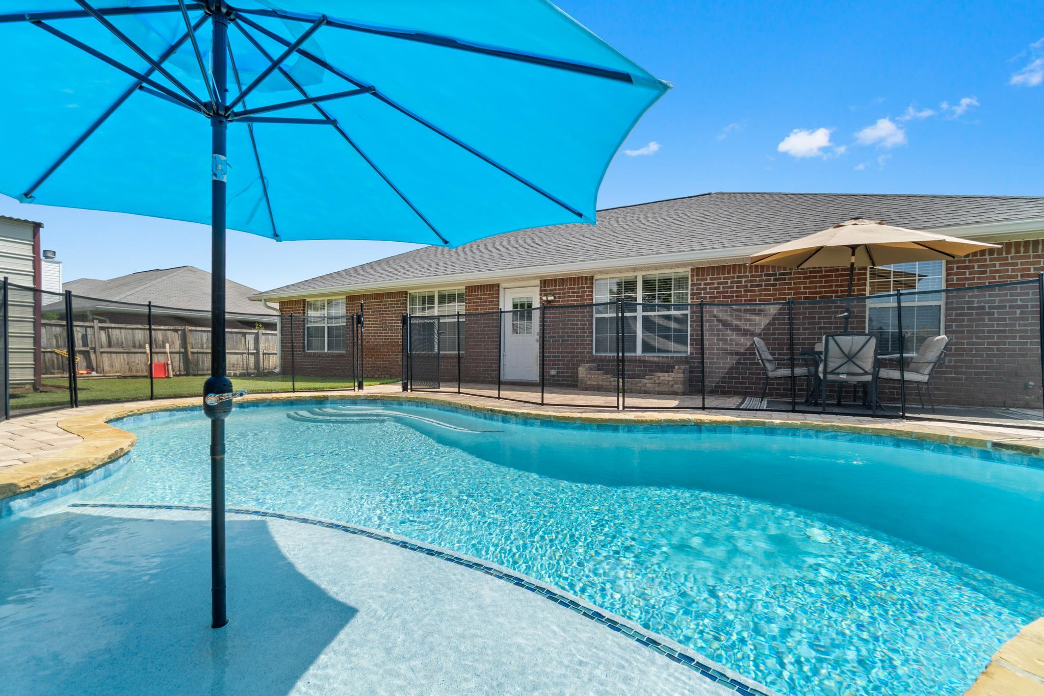 Welcome to this beautifully updated east Navarre POOL home! With 4 bedrooms, 2 baths on a corner lot with a backyard oasis featuring an in ground gunite saltwater pool, it's time to enjoy Florida living! Pull up into the driveway (completed with an extended pad on either side) and appreciate the impeccable curb appeal complete with palm trees. Walk inside and tile flooring greets you that extends into the kitchen. From the entryway you'll love the open floor plan with laminate flooring extending through the living room and brand new carpet in each of the 4 bedrooms. The spacious living room has a vaulted ceiling and is open to the eat in kitchen space, which leads to the well appointed kitchen with refinished cabinets, new sink and faucet, and stainless appliances. The split floor plan allows for master bedroom privacy. A great sized bedroom leads to a spacious en suite with double vanities (new sinks and faucets), a walk in closet (brand new carpet), a separate shower (new shower door and shower head), soaking tub, and private walk in closet. One of the additional bedrooms is located off the living room so it makes it also perfect for an office, playroom, or game room! The other two nice sized bedrooms are down the hallway and share a full bathroom. Outside this house truly shines even more with a stunning in ground salt water pool with a built in tanning ledge (the pool umbrella will convey) and seating surrounded by pavers! Have peace of mind with a child safety fence that can be removed if wanted. Inside the fully privacy fenced backyard you'll also find a producing blackberry bush and producing peach tree, and as well as a new pear tree and roses. To finish off this great space there is a large storage building for all your storage and/or backyard equipment needs. Don't delay on seeing this rare gem! Showings start Tuesday, 9/7.