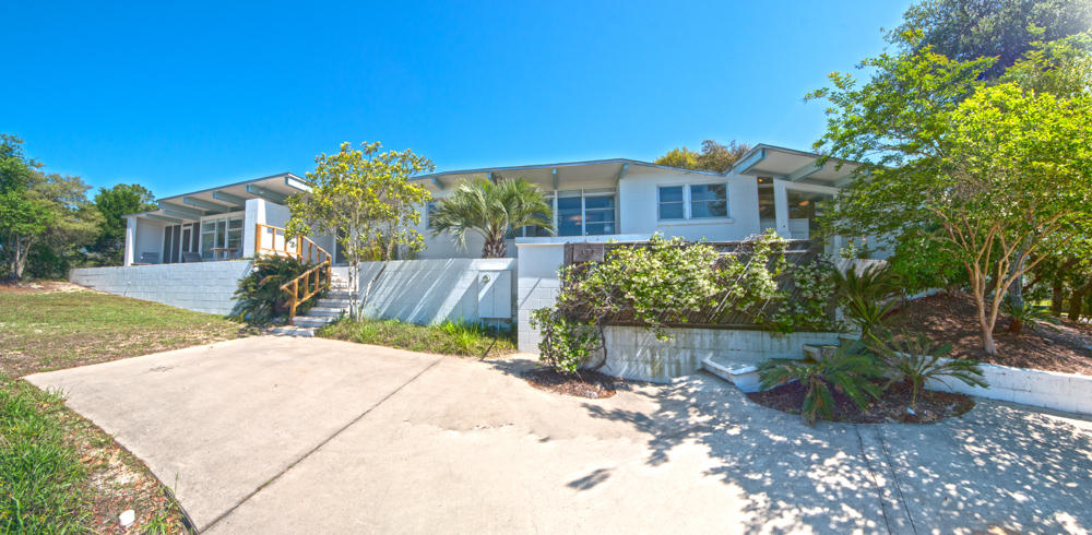 This 1.3 acre site, sits high atop the dunes with an elevation and setting you have to see to believe! This spectacular and unique home is the only one available in the private and gated enclave of Four Mile Village. A contemporary, classic style home designed by a student of Walter Gropius, Harvard Architecture Chairman. This sprawling one story home offers expansive views from both sides, spanning the Gulf of Mexico to the south and Fuller Lake, a pristine 60 acre coastal dune lake to the north. A private dock is avail to enjoy lake activities. The home offers a private setting with 3 bedrooms and 3 baths, perfect for family with two spacious living areas and kitchens. A detached garage and storage area are tucked among the beautiful oak trees. Four Mile offers 2200 ft of private beach access. Experience living within this one of a kind gated community bordered by Coffeen Nature Preserve & Tops'l Hill State Park. Hike the trails, kayak and fish in the lake and enjoy this unique and quiet, gated gulf front community...YET...Just across the street from all major amenities such as restaurants, shopping, entertainment, golf, tennis, hospital...This location and setting offers the best of both worlds! Buyer to verify all dimensions and information.
