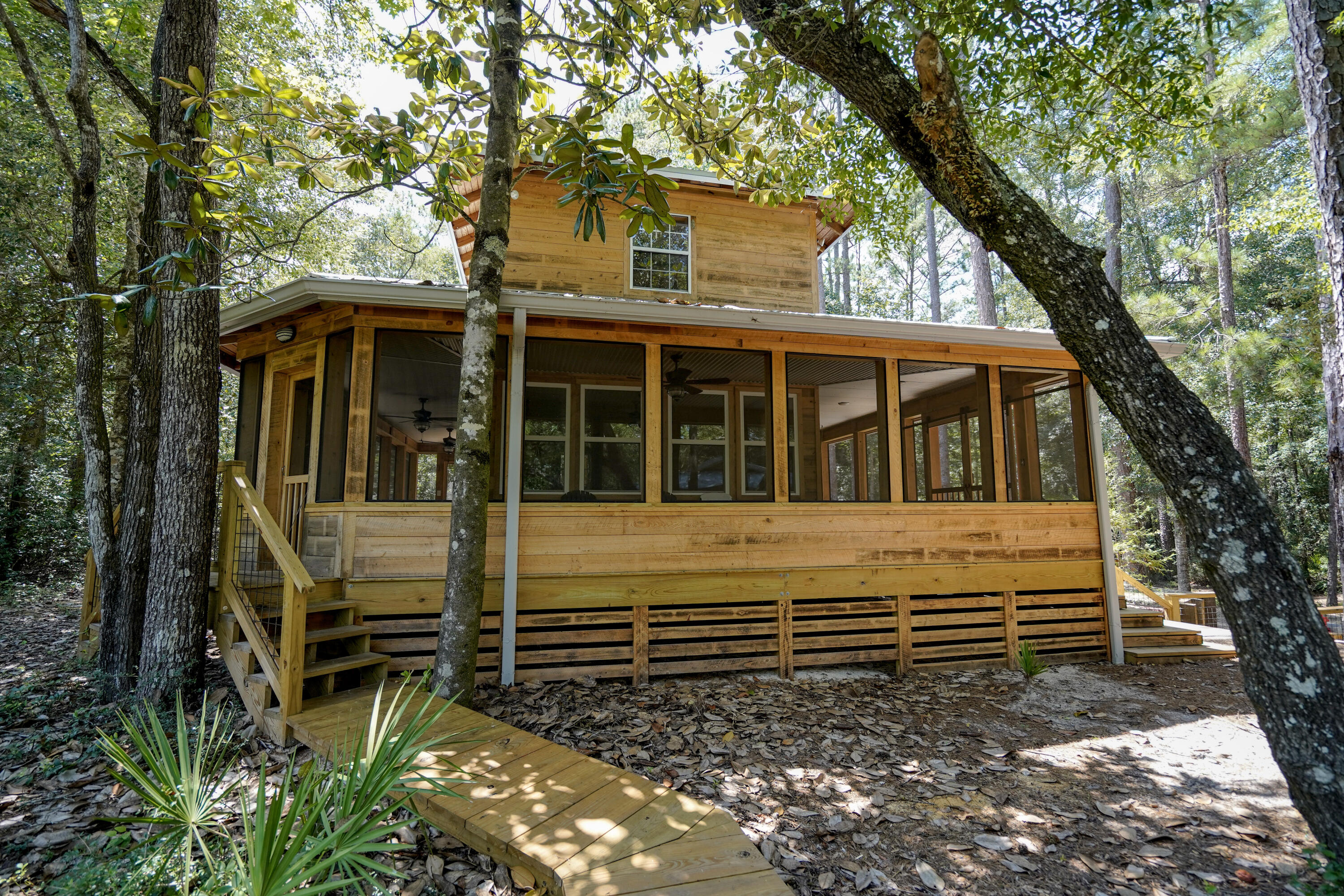 Two lots being sold together. This is a completely off the grid river camp or hunting lodge with a boat launch and a covered picnic area.  It has solar panels and a whole house. generator as well as two mini splits and the water source is an artesian spring fed well.  It has a creek running through the front part of the property and it sits directly on the Shoal River with a bluff across the river so it is very secluded. It has a rain shower outside, a dock, it has a complete kitchen with all new mini appliances, it even has a washer and dryer inside.  Wrap around screened in porch complete with a porch swing.  Includes a polar cowboy plunge pool and covered mini pole barn.  This is a unique one of a kind get away property yet close to town.   15 minutes from grocery stores and restaurants.  Lots of wildlife - this area is rich in local history.  It is the perfect getaway with potential for short term rentals.  It has foam insulation blown in and two sleeping areas upstairs with beautiful views of the river. It has never been rented, or used, so everything is brand new.  Hand burnished cypress exterior.  The buildout was a. labor of love.