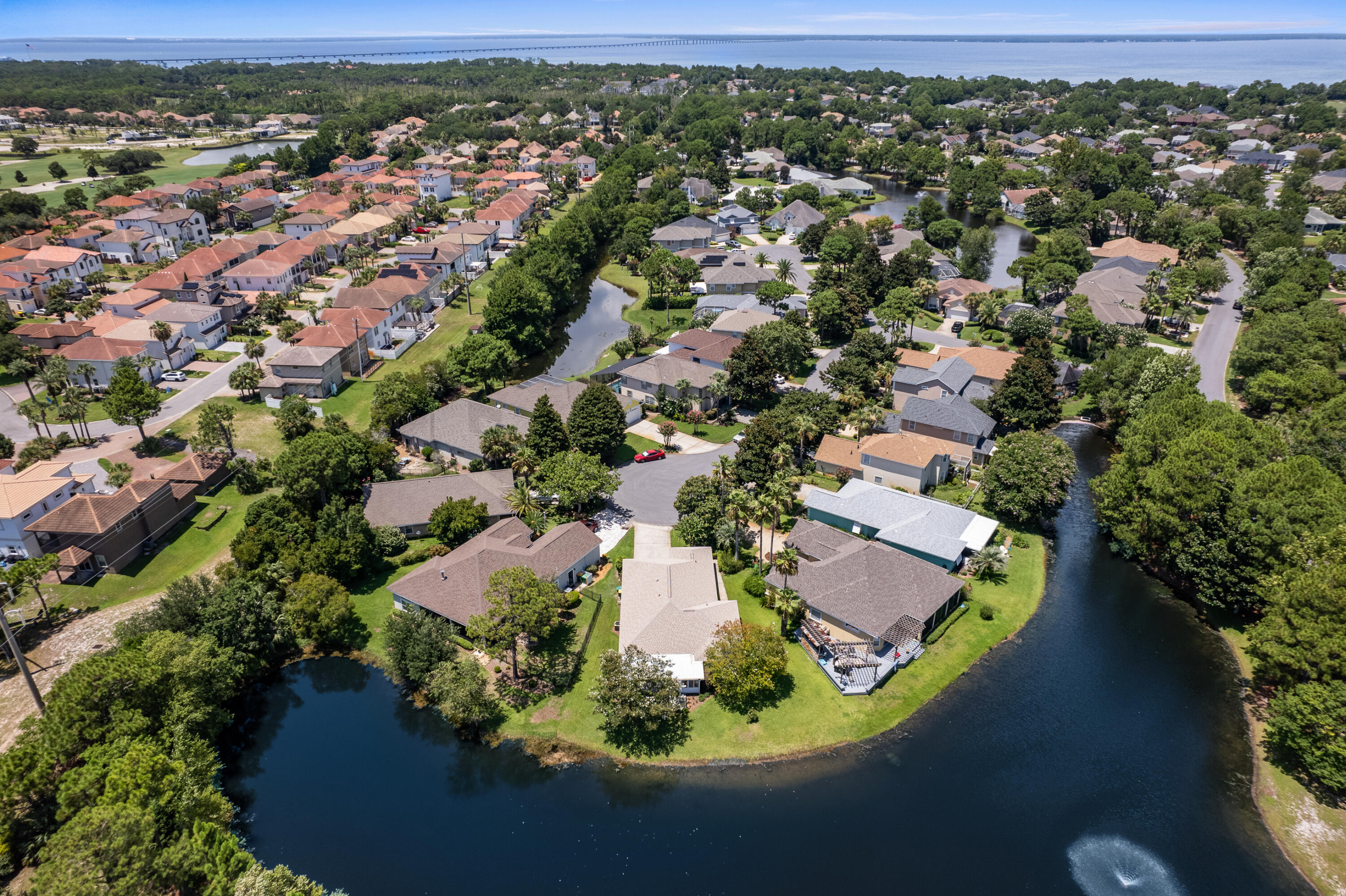 MOTIVATED SELLER!! REDUCED PRICED!! Beautiful lakefront home located in Destin's Emerald Lakes subdivision. This single-family home boasts recently installed bamboo floors throughout, and features an enclosed Florida room with an additional 312 sqft of cooled & heated space with stunning water views. For those who prefer outdoor relaxation, there's a wood deck nestled under mature trees, perfect for unwinding in the evenings. The home is situated on a cul-de-sac at the front of the neighborhood, offering a sense of privacy and tranquility.
Recent upgrades include a 2023 hot water heater, 2022 roof, 2024 new exterior paint, and 2019 HVAC air handler with a UV light system installed to improve the indoor air quality.  The large kitchen is equipped  with 2019 modern black stainless steel appliances and includes a bar area that overlooks the dining room, seamlessly flowing into the open-concept living room with vaulted ceilings. The split floor plan ensures privacy, with the master bedroom featuring tray ceilings, a private bathroom with double vanities, double mirrors, a standup shower, a separate jetted tub, and a walk-in closet, all set towards the back of the house overlooking the lake. On the opposite side of the house, you'll find two additional bedrooms and an extra one and a half baths, including a separate guest bathroom located by the living room. The property also includes a two-car garage with plenty of storage space and a driveway for overflow parking. This home comes with hurricane shutters and pest control tubes that run through the interior walls of the homes for easy treatment. The enclosed Florida room has hurricane proof windows that withstand hurricane-force winds up to 160 mph. This homes has it all.  

Emerald Lake offers gated entry for added security, a community swimming pool, and two lighted tennis courts. The neighborhood is adorned with lush green lawns and seven freshwater lakes, ideal for fishing, kayaking and canoeing. Additionally, the community pavilion features a picnic table, basketball court, swings, and a new playground for children. Nearby, you'll find two golf courses in adjacent neighborhoods, making this a perfect location for leisure and recreation.