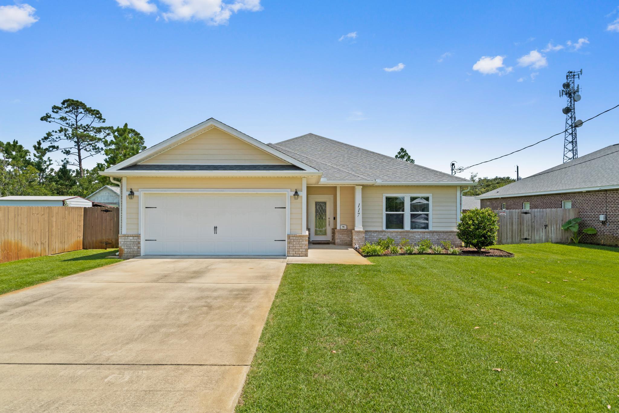 Welcome home to this gorgeous and practically new Mary Esther retreat just minutes to Hurlburt Field's front gate! Built in 2017 with all the lovely finishes and upgrades you're wanting, you're going to fall in love with this move in ready beauty. Pull into the long driveway and appreciate the impeccable landscaping, and make your way to the custom glass front door. Inside you'll find tile flooring extending through all the common areas with crown molding and a stunning TRIPLE trey ceiling in the large living with recessed lighting! You'll love this open concept floor plan with an eat in kitchen space open to the living room as well as the well appointed kitchen where you'll find granite countertops with a breakfast bar with room for seating, stainless appliances, and upgraded fixtures. The master bedroom is also full of updated features and you'll notice the double trey ceiling as soon as you walk in! The master bath is stunning with double granite counters, a soaking tub, separate shower, TWO walk in closets, and a private water closet. The two additional bedrooms are nice sized with ample closet space and they have a full sized bathroom between them featuring double vanities and gorgeous granite counters. The interior laundry room has additional storage space and leads to the two car garage. Inside the attic you'll also find additional storage as the sellers put down plywood to extend the usable space! Outside you'll love relaxing on the 10x20 covered back patio overlooking extremely well cared for lawn within the fully fenced in backyard completed with an outside storage building. Don't miss out being minutes to beautiful Emerald Coast beaches and the best that Florida has to offer!