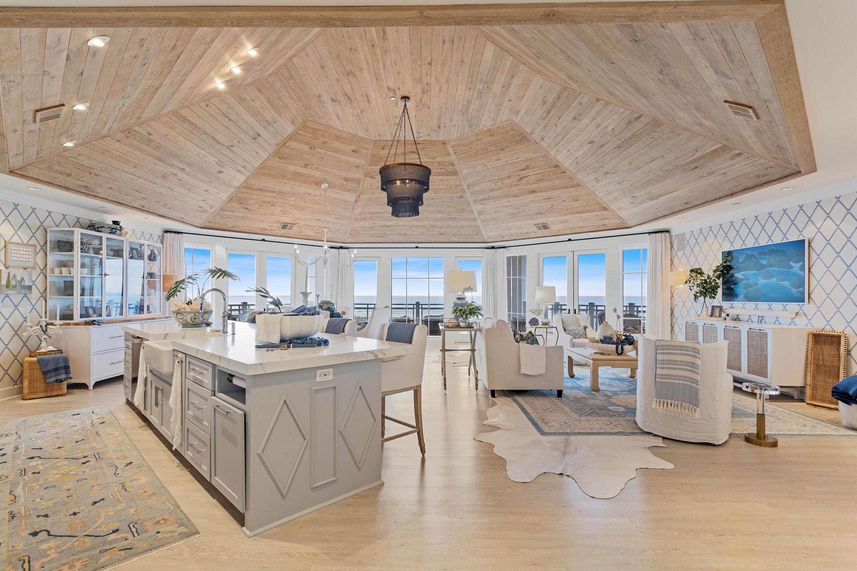 This luxury penthouse dares to challenge convention with a semi-octagonal floor plan that maximizes gulf-front views within the exclusive WaterSound development. Soaring 20-foot ceilings, oversized windows and an interesting open floor plan create a fabulous beach home that can never be termed 'dull and boring.' Coastal architecture includes the best of Southern living with deep porches and wide overhangs creating shady seating areas with unobstructed dune and gulf views. Turn-key, fully furnished and designed by Graham Gund Architects of Boston, this stunning beach home boasts wide-plank flooring and fabulous decor and furnishings by VLG Interiors.  The entire space was inspired by the shimmering Gulf of Mexico, uniting comfortable living spaceThe hub of the angular great room is the seating area where you can relax, socialize or just enjoy the mesmerizing gulf views through multi-aspect windows. There's a designated dining area, office space, wet bar with wine refrigerator and a huge island heralding the gourmet kitchen. Sip drinks on tall dining stools while admiring the gorgeous veined quartzite countertops, backsplash and Viking stainless appliances. Gulf-inspired shades of blue create a light, bright living space beneath the rustic timbered ceiling. Tucked out of sight, there's a spacious laundry and half bath. Doors open onto the wraparound deck space allowing owners to enjoy the stunning dune and gulf views from the comfort and tranquility of their own beautifully furnished hideaway. Large closets, coastal decor and a Whirlpool soaking tub feature in the master suite with two further guest beds and four baths rounding off the accommodation. WaterSound is renowned for its amenities including gated security, neighborhood pools, walking trails, a puttering park and shopping and dining, which are all golf-cart accessible. Located between Deer Lake State Park and Camp Creek Lake, the area abounds with recreational opportunities for hiking, fishing, kayaking and paddleboarding. The property also includes a full St. Joe membership, opening the door to world-class golf and tennis facilities.