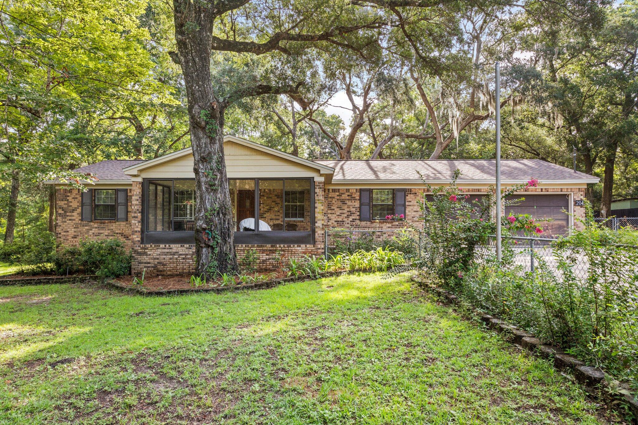 This inviting 3-bedroom, 2-bath, single-story all-brick home offers comfort, style, and functionality on a large, mature acre lot. A screened-in front porch with stylish black shutters and a solid wood front door sets the tone for the warm welcome inside. Step into the entry with luxury vinyl plank flooring leading to a spacious living room, filled with natural light from multiple windows. Detailed architectural touches frame the second living area, while the galley-style kitchen features an eat-in dining space, updated designer hardware, and a stainless steel refrigerator. The separate living space offers a large ceiling fan and French doors for added charm. The guest bath boasts updated lighting and a shower-tub combo, while each bedroom is complete with ceiling fans and ample natural light. The primary suite includes a double closet, a large bathroom vanity, and its own shower-tub combo. The oversized garage includes a washer and dryer, while the expansive fenced backyard is a true highlightfeaturing a Florida room, a shed with a garage door, electricity, and workbenches. Surrounded by mature trees, this property combines classic construction with modern updates, offering a versatile space for relaxing, entertaining, or pursuing hobbies. Call for your showing today!!