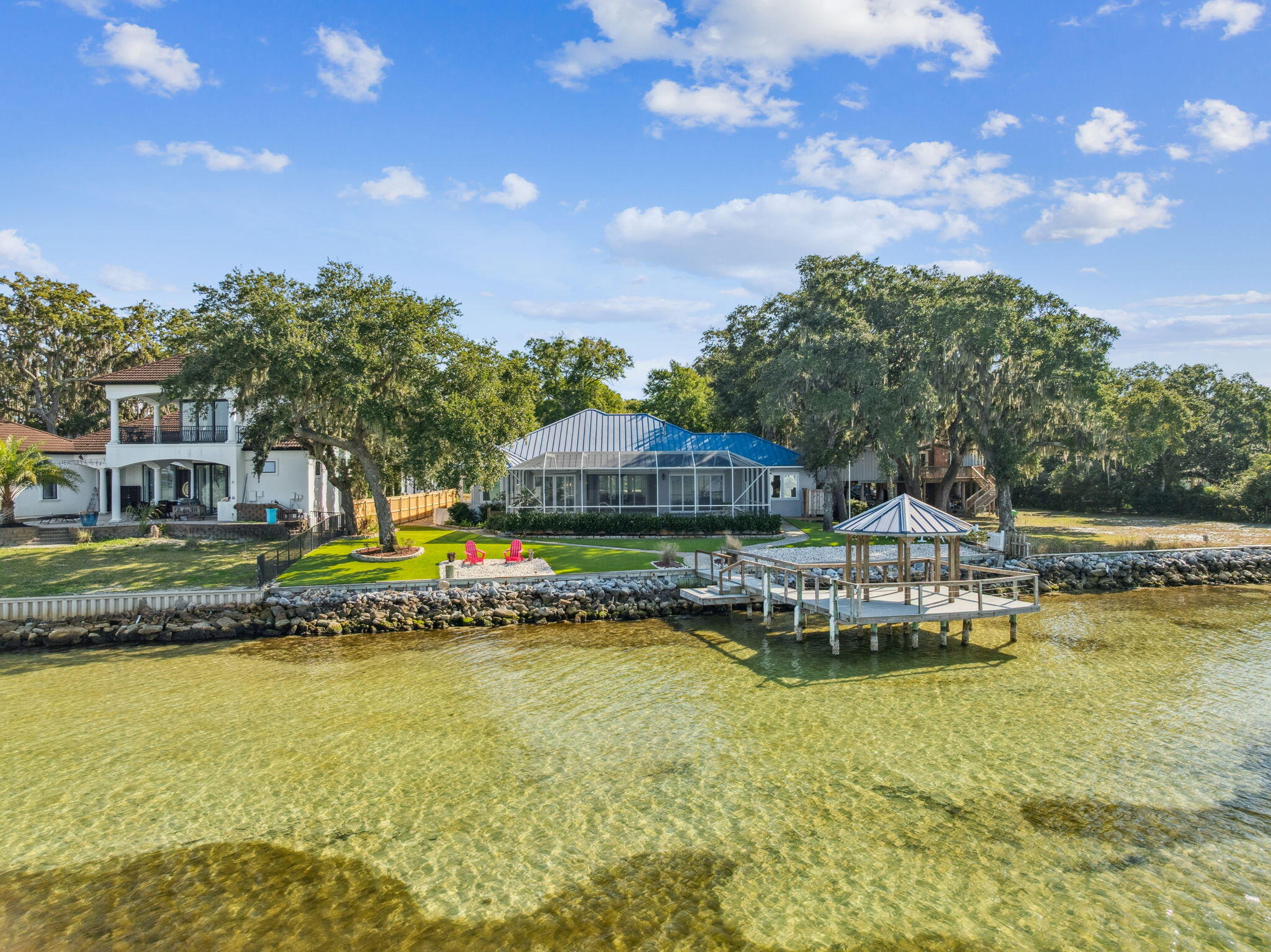 Located on the historic site of the original Marler homestead—the founding family of Destin—this premier bayfront estate offers a rare combination of heritage, luxury, and modern resilience. Nestled on nearly an acre of Choctawhatchee Bay frontage, this private sanctuary was designed for the ultimate coastal lifestyle. Built in 2012 with hurricane-resistant ICF (Insulated Concrete Form) construction, the 3,091 sq. ft. residence is as sturdy as it is beautiful, featuring a full-house Generac generator and a geothermal HVAC system (2022) for maximum efficiency and peace of mind. The thoughtful interior boasts a split-bedroom floor plan with 4 bedrooms and 2.5 bathrooms, anchored by a gourmet kitchen with a large central island, walk-in pantry, and high-end finishes. Elegant architectural details like tray ceilings and a gas fireplace lead to a massive 28x20 Florida room that captures stunning water views. Outside, the gated 0.85-acre retreat offers roughly 100 feet of bay frontage, a private dock with immediate access to the East Pass and Crab Island, and a screened-in, heated gunite pool. The immaculate grounds are shaded by mature oaks and magnolias, complemented by new low-maintenance synthetic turf for a pristine look year-round. This is a rare opportunity to own a piece of Destin history with the modern comforts of an elite waterfront estate.