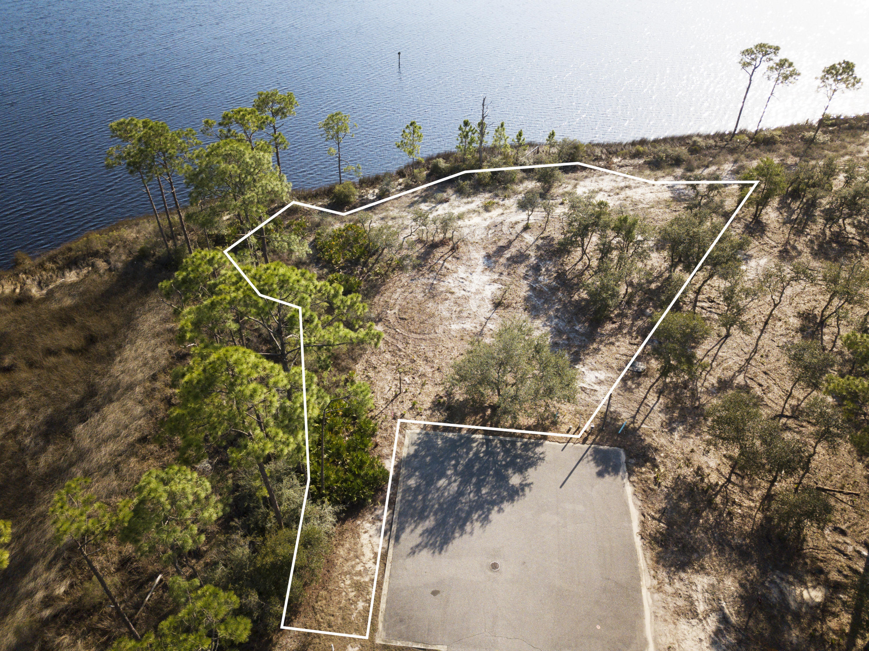 Enjoy your very own lakefront views on this expansive, secluded home site in the coastal community of Wild Heron. This lot boasts over 200 feet of lake frontage, views expanding towards the east and west, a boat permit and all of the luxury amenities this community has to offer. Located on a 700 acre preservation residents are tucked away in a quiet and secluded area with plenty of privacy.
With an active HOA, Wild Heron also offers fantastic amenities like access to the Shark's Tooth Golf Club and Club House, a community pool, a state-of-the-art fitness center, a large playground and a boat house where homeowners can enjoy using the paddle boards and kayaks on lake Powell.