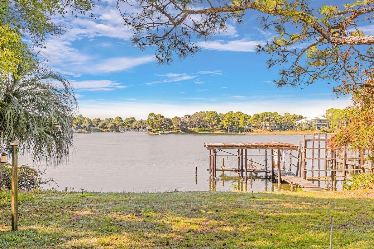 Family-owned since 1970, this unique property on Joe's Bayou is all about privacy in a stunning waterfront location. Keen boaters, fishing enthusiasts and water sportsmen will envy the dream lifestyle this .9 acre property offers in old Destin. The exclusive waterfront location includes a boat house and a 100-ft. dock for lining up your boats and water toys on the highly desirable deepwater bayou. The original home and dock are in need of renovation or a rebuild, but there's heaps of potential. The flexible floor plan currently has two large indoor living areas spilling outside onto an entertaining deck with endless views across Joe's Bayou. There's a spacious family kitchen for creating your own chef-worthy domain. The open great room has a cozy fireplace and a wall of windows framing unspoiled bayou views. Step out onto the elevated back porch and appreciate the vantage point that this home currently enjoys. Four large bedrooms including two oversize masters have their own en suite facilities and there are two outdoor showers for rinsing off. This home oozes potential for those wanting to make their own mark. It could be gated for additional privacy with optional access from Bayou Drive or a side street. This private enclave is just a hop from beautiful beaches, 30A shopping and dining, and all that Destin has to offer. It's definitely worth considering for anyone looking for a private weekend escape to fly into by private jet. With a working budget for renovation, this home will have instant equity compared to similar updated homes on the bayou.