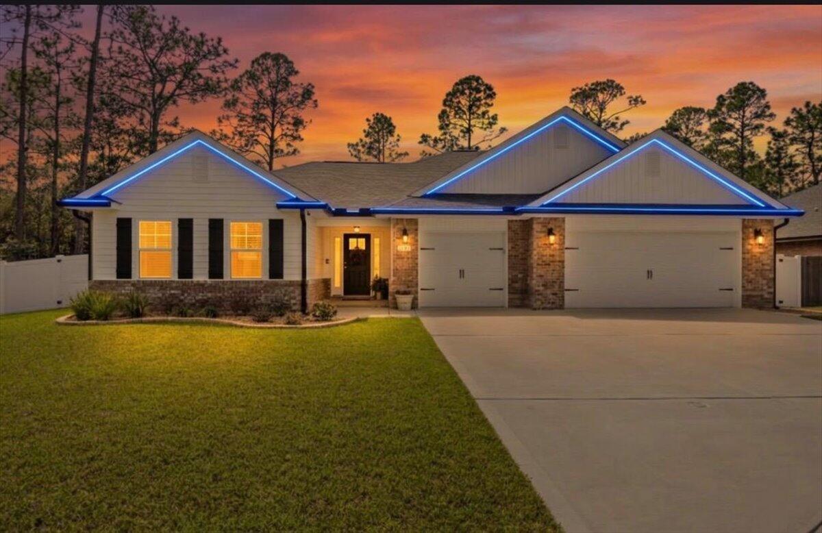 Welcome to Creets Landing in Navarre, Florida, where thoughtful design meets modern luxury. This one-of-a-kind floor plan is unique within the entire community and offers custom upgrades, stylish finishes, and exceptional indoor-outdoor living. From the moment you arrive, the curb appeal sets the tone. The property features a 6-foot vinyl privacy fence and extensive hardscaping upgrades, including a beautifully designed patio, walkway, and landing area that create inviting outdoor living spaces. Entertain with ease in the outdoor barbecue gazebo area or relax year-round in the screened-in lanai porch. Permanent ShawTech lighting adds both elegance and convenience, highlighting the home with customizable exterior lighting. Once inside the entryway is highlighted by an elegant custom wainscoting foyer accent wall, creating a refined first impression. The living room features a custom shiplap media wall designed to accommodate up to a 77-inch television, making it the perfect focal point for relaxing or entertaining. The kitchen blends functionality with upscale design, featuring a tiled backsplash, under-cabinet lighting with dimmer controls, and dusk-to-dawn accent lighting above the cabinets that adds warmth and ambiance. A custom butler's pantry provides additional storage and workspace, complete with a dedicated 20-amp outlet and motion-sensor lighting for added convenience. The primary suite serves as a private retreat with another elegant custom accent wall, while the walk-in closet features custom shelving to maximize organization and storage. This exceptional home combines custom craftsmanship, modern lighting design, and beautifully curated indoor and outdoor living spaces, all within minutes to the Emerald Coast beaches of Navarre.  A truly distinctive property you won't find replicated anywhere else in the neighborhood.