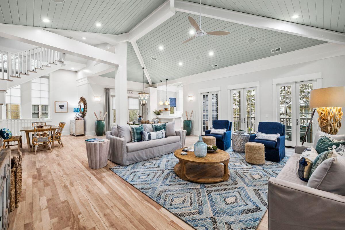 Just steps from the shores of Western Lake, this exquisitely updated home stands as a testament to architectural ingenuity, originally designed by the renowned Tom Christ. Nestled in Park District of WaterColor, its exterior and interior have been meticulously repainted, showcasing a fresh, new look. With soaring ceilings, the home radiates a like-new ambiance, featuring refinished wood flooring, brand-new appliances, and elegantly selected furnishings. Boasting a proven rental history, this magnificent property is not only a luxurious coastal retreat but also a lucrative investment opportunity, making it highly appealing for discerning buyers. The thoughtful design includes a practical mudroom and laundry area on the first floor, ideal for managing sandy excursions and beach towels. Each of the two spacious bedrooms on the first level, one of which is a bunk room, offers a haven of comfort, complete with private ensuite bathrooms and walk-in closets. Ascending to the second level, the residence unfolds into a stunning open-concept space, combining the kitchen, dining, and sitting areas under a magnificent wood-lined ceiling. Abundant natural light floods in through large windows and doors, illuminating each artfully arranged space. The kitchen, recently updated, strikes a balance between modern and coastal aesthetics, featuring white cabinetry, sleek quartz countertops, and high-end appliances. The master suite is an embodiment of tranquility, boasting a lofty beamed ceiling, a cozy sitting room, and a private porch with verdant views. One of the suites includes a secluded sleeping porch, perfect for savoring the refreshing coastal air. The third-floor tower offers a spectacular vantage point for admiring sunsets over WaterColor.

Behind the home, a paved parking area leads to a two-car garage, which houses a nearly new golf cart. Above the garage lies a charming carriage house, complete with a kitchenette and full bath. The screened porch invites relaxation with cushioned swing seats, while the side patio offers a perfect spot for stargazing around the fire pit. This extraordinary home is a rare find for those seeking a luxurious coastal lifestyle in Florida, conveniently located near various restaurants and Club WaterColor amenities.