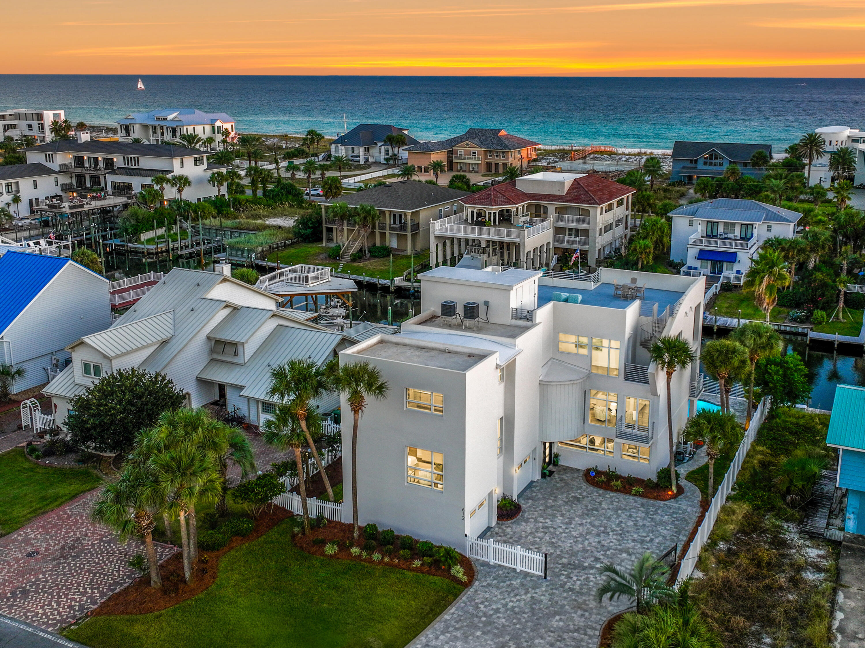 NEW LISTING! Welcome to 612 Magnolia Drive, an exceptional waterfront estate oriented on the deep waters of the scenic harbor of Holiday Isle, an exclusive, and very rare, beach and boating enclave in Destin, Florida. This furnished deep-water residence on the canal yields ±6,000 square feet of luxuriously renovated living space, containing 4 bedrooms and 4.5 bathrooms, and an extraordinary combination of design, quality, craftsmanship, and functionality throughout. The expansive layout is enhanced by soaring ceilings and floor-to-ceiling windows that naturally illuminate the home while offering breathtaking waterfront vistas. Interior features include an elevator, dual laundry rooms, quartz countertops, custom cabinetry, Viking appliances, automated window treatments, Kinetico water softener, reverse osmosis drinking system, and tankless water heaters. The outdoor living area offers expansive entertaining spaces, a dock with 16,000-pound boat lift, and a heated saltwater pool that seamlessly integrates its indoor comforts with Destin's quintessential waterfront lifestyle. The rooftop deck, accessible by both elevator and spiral staircase, captures breathtaking 360° panoramic views of the Gulf of America, the Destin Harbor, Intracoastal Waterway, and Choctawhatchee Bay; the perfect vantage point for year-round sunrises and sunsets. The residents of Holiday Isle enjoy two private, gated points of access to the world-class beach, extremely reasonable annual Association dues of only $593.00 [currently] for 2025, and a lifestyle defined by convenience and proximity and access to sugar white sand beaches, world-class boating, fishing, dining, and shopping along the Emerald Coast of Northwest Florida. Destin's newest Publix just opened, within a 5-minute drive from Holiday Isle on Main Street.  Please note documents available under the "Documents" tab. Private showings are by scheduled appointment only with a minimum (24)-hours of required advanced notice.  The listing broker(s) must accompany all showings.
