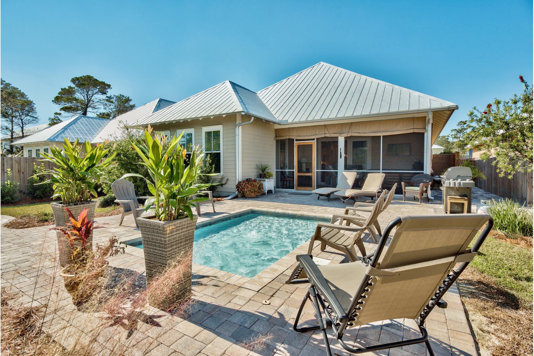 Spyglass Hill is an intimate grouping of homes less than half a mile from beach access at Ed Walline Park, located along Scenic Highway 30A at Gulf Place. This attractive home is situated on a large lot with a spacious backyard surrounded by lush manicured landscaping. Outdoor screened porch and a chic water feature will allow for complete relaxation. Additional exterior features of this home include a metal roof, Hardie board siding, pine ceilings on both front and back porches as well as Jeld Wen Premium impact windows. Beyond the mahogany front door, the theme continues with cottage cased windows, two-panel doors, six-inch base, and two-piece crown molding that accents the 10-foot ceilings throughout the first floor. Oak floors carry throughout the principal living areas. Wood cabinets, granite counters, and stainless steel appliances that include a coveted gas range appoint the kitchen. Its nearly 12-foot long island features a stylish arched bar top that connects the kitchen with the dining room area and allows for seamless entertaining. The adjoining living room area features a corner gas fireplace and three-panel sliding glass door that leads to the 12-foot deep covered screened porch, which can also be accessed from the master bedroom. Flanking the entrance to the master bath are two walk-in closets. The bath features a walk-in shower, a water closet as well as a double vanity crowned with a clerestory window that adds natural light to the space without sacrificing privacy. The guest bedroom at the front of the home features side-by-side closets and access to a nearby guest bath while the second guest bedroom features a walk-in closet and private bath with shower/tub combination. The second-floor bedroom with private bath is a versatile space that could serve as a home office, play room or media room. An enormous walk-in closet with two-tier hanging racks includes easy access to plentiful attic storage. Come enjoy this home and its proximity to the beach, as well as shopping, dining and seasonal entertainment at nearby Gulf Place. Highway 98 is a straight shot north on 393, just over one and a half miles from Spyglass Hill, providing convenient access to Destin and Panama City Beach.