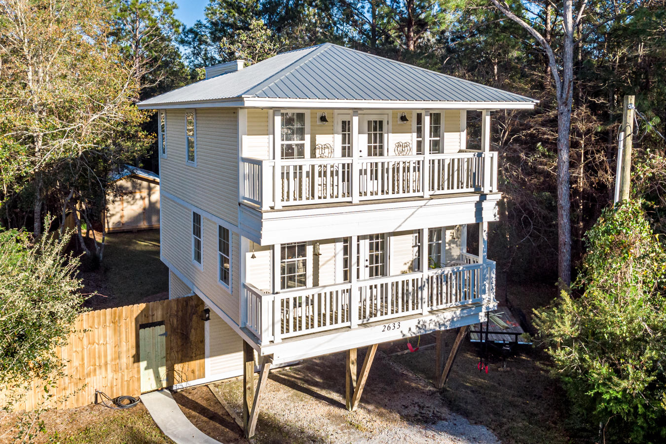Lovely 3 story home with many updates and just 10 minutes from the beautiful beaches along 30A! Charming covered porches on the upper 2 levels.  This home offers spectacular sunset views over the bay from the upper levels. Great privacy fenced backyard with 2 storage barns. Rich hardwood flooring throughout.  Updated kitchen with stainless steel appliances, ceramic tile backsplash and a dining area.  The lot is large enough to store a boat and the brand new boat launch is just down the street! Conveniently located nearthe beach, shopping and dining.