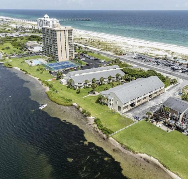 One of a kind, 1 bd, 2 bth, Sand Dollar townhouse style condo with gulf views and dedicated carport with Little Sabine at your back door. Pictures do not do this condo justice! 
 Living room boasts 17-ft ceilings, kitchen with gulf views, all on your main living level. Second level hosts your spacious private bedroom and overlooking balcony. Additional upgrades include: new ceramic tile floors to the entire unit, quartz countertops, and new flooring to the stairs.
Walking distance to sand, restaurants, and pier