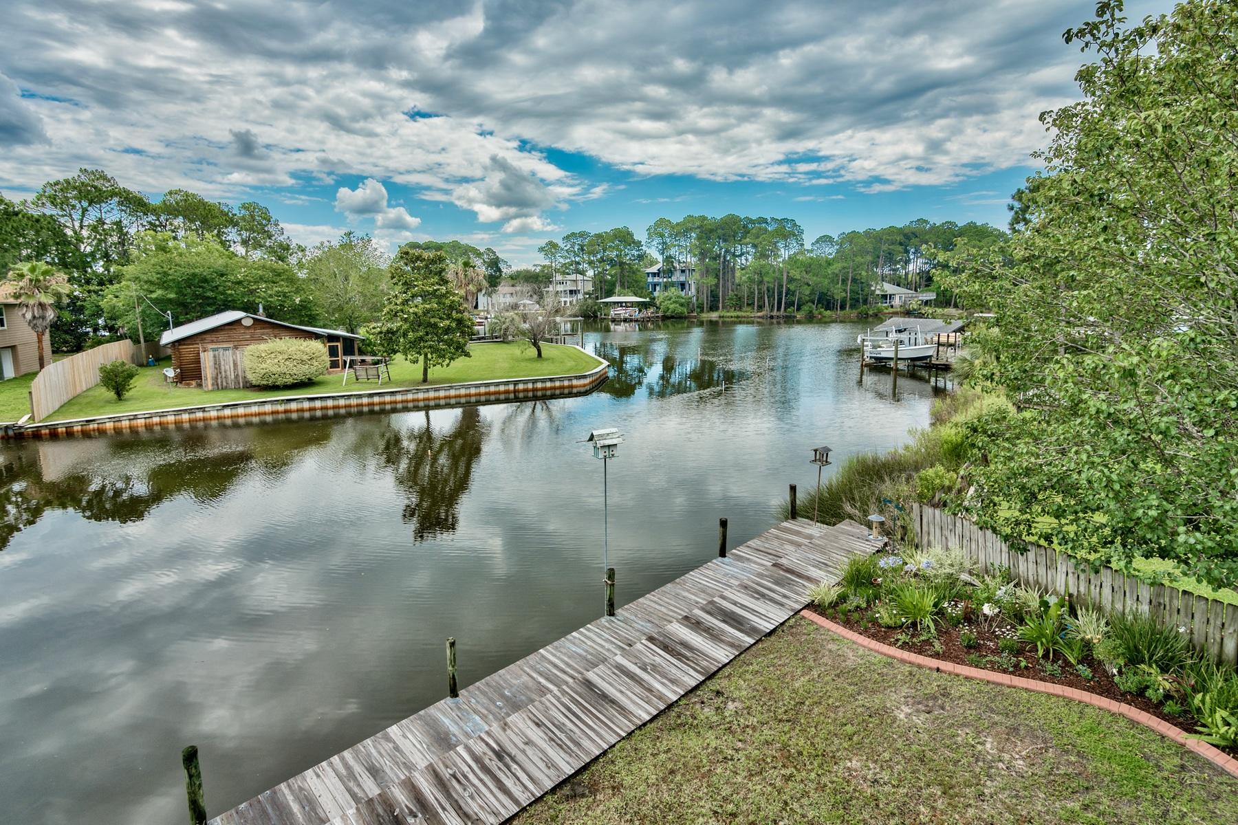 An amazing opportunity to own a waterfront home in Santa Rosa Beach for under $500,000! This lovely dwelling is a boater's paradise boasting 120 feet of private water frontage with seawall, deep water access, and a 12,000 lb boat lift and private dock. This one owner, custom built home is just a 5 minute boat ride to Baytowne Wharf and a 15 minute ride by boat to Crab Island. Each room of this coastal home displays lovely water views of Buck Bayou while huge porches invite you to hours of relaxing and entertaining as the sun rises on your very own piece of paradise. Across the street is Sandestin preserve which will not be built on maintaining a fabulous view of the woods.  Inside this 3 bedroom 2 1/2 bath home, freshly painted living spaces and new hardwood flooring greet you upon entry.  The gathering area is open an airy and flows effortlessly into the dining room.  A spacious chef's kitchen featuring granite countertops, new stainless steel appliances, and a breakfast bar with plenty of seating for your guests makes cooking and preparing meals a pleasure.  The master bedroom is just off the main living area featuring a master bathroom with garden tub, double vanities and granite counter tops.  Parking is no problem with a 2 car garage, expansive driveway and an additional parking pad to accommodate your boat and your RV.  Close proximity to shopping and restaurants at Grand Boulevard, Sandestin, and Silver Sands Factory Outlets.  Living on the water has never been more accessible!  Make the dream of waterfront living your reality, today!