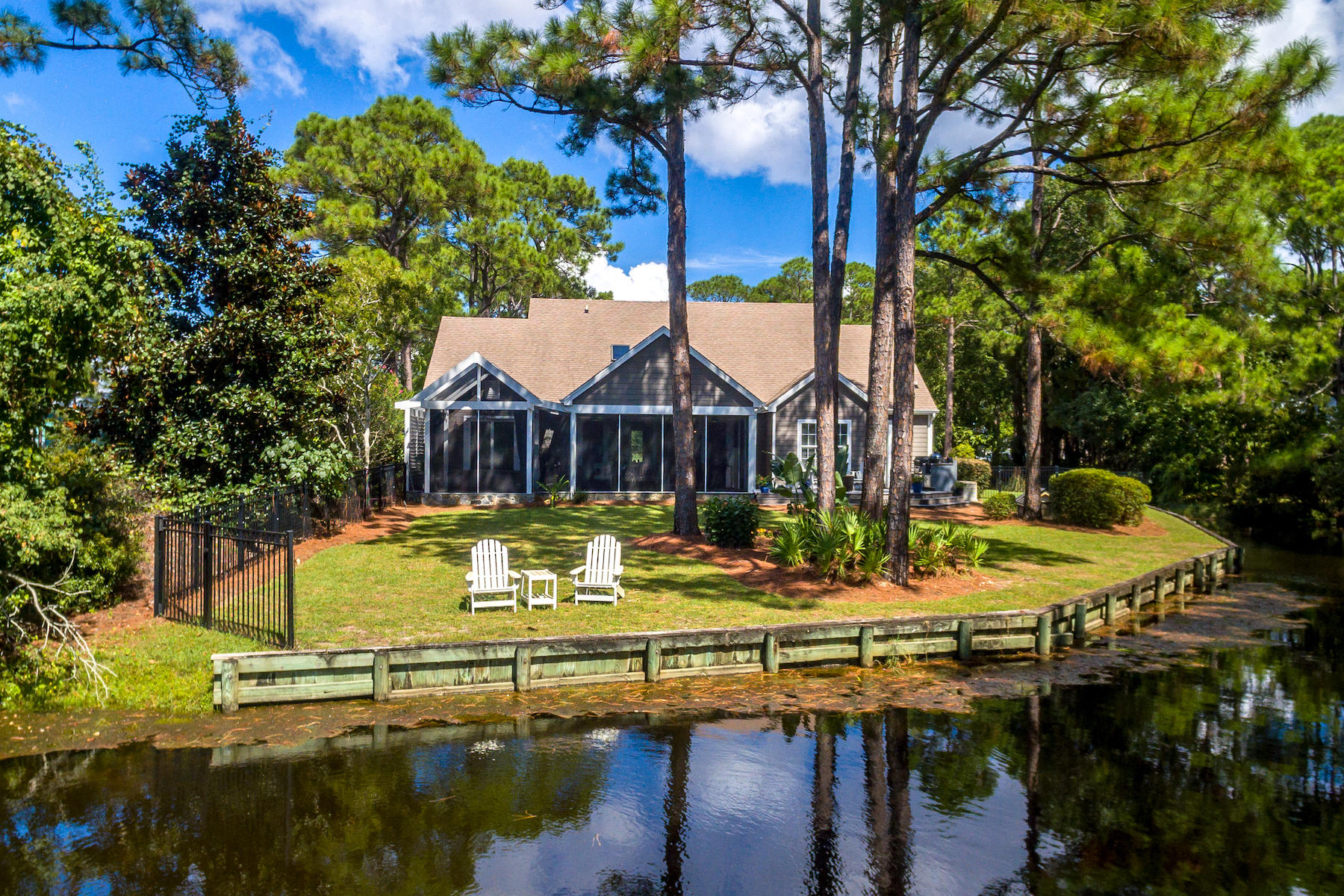 You crave high style and lush appointments. Long walks and friendly neighbors without the cost and commitment of an HOA. A retreat that honors privacy yet begs to entertain. Enjoy waterside living on one-half acre of privacy overlooking a meandering, spring-fed, brackish lake and within bird's-eye-view of the Choctawhatchee Bay. This well-built home has been continuously renovated/ improved under the current owner. From kitchen renovation to architectural detail, this home reflects fine design and extreme comfort. Indoors blends seamlessly with outdoors through retractable doors leading to a spacious screened porch joined by open decking with an outdoor kitchen. Party guests linger longer when the indoor/outdoor Sonos Surround System plays Etta James and the smoker hints at pork for dinner Curb appeal is unmistakable -  a circular drive is flanked by azaleas and roses and overlooked by a rocking chair front porch. Inside, the drama of the transitional architecture belies the simplicity of the traditional exterior.  White beams accentuate the 24-foot living room ceilings; skylights highlight the soft gray hue of the walls. A downstairs office enjoys a view of the bay. Its built-in desk, file drawers, and extensive shelving support an at-home work environment and an extensive library. Formal dining is spacious and open to living, details include chair-rail and gray-toned wallpaper. Living/kitchen/breakfast are open concept and are designed for compelling acoustics and memorable gatherings, all with stunning lake views. A white-kitchen with black counters features expansive, custom cabinets, Kitchenaide oven/convection and cooktop, a Subzero refrigerator, and a Bosch dishwasher. A sunny kitchen window overlooks a canal leading from the lake to the bay with a steady stream of jumping mullet fish for entertainment. An impressive full wet bar with a 180-bottle Subzero Wine fridge and ice-maker is entertainment central. The breakfast area does double duty as a wine-tasting station. The downstairs living area is completed by a memorable powder room. The original screened porch has been enhanced by additional decking and a screened-porch addition with an eight-person hot tub. The master suite was redesigned to allow direct access to the hot tub. The master includes two closets and a custom built-in wall unit for additional hanging and drawer space. The TV and entertainment system is cleverly hidden behind retractable doors. The master bath renovation makes optimal use of space with a large shower and clever built-ins. Bruce flooring is featured downstairs and up in most rooms. Upstairs, iron railings accent an open loft with a built-in desk. Two bedrooms (one currently used as a writing room) share one bath. The large backyard is fenced with a mesh overlay to prevent small dogs from exploring off property. The lake provides a year-round playground for wild-life. Egrets fill a distant tree with snowy white in early spring and turtles hatch and raise their sleepy heads. Summer brings noisy bullfrogs and cool evening breezes. And before you ask â€“ there has never, ever been any evidence of an alligator. This home survived Hurricane Michael without any damage or flooding. It's full house generator prevented any interruption in power. 375 Bayshore Drive is a lovingly renovated, much enjoyed, conveniently located retreat near shopping, dining, entertainment, and beaches. Legion Park is located at the east end of Bayshore Drive and includes a children's playground and boat ramp. Make your appointment to see this well-appointed home today.