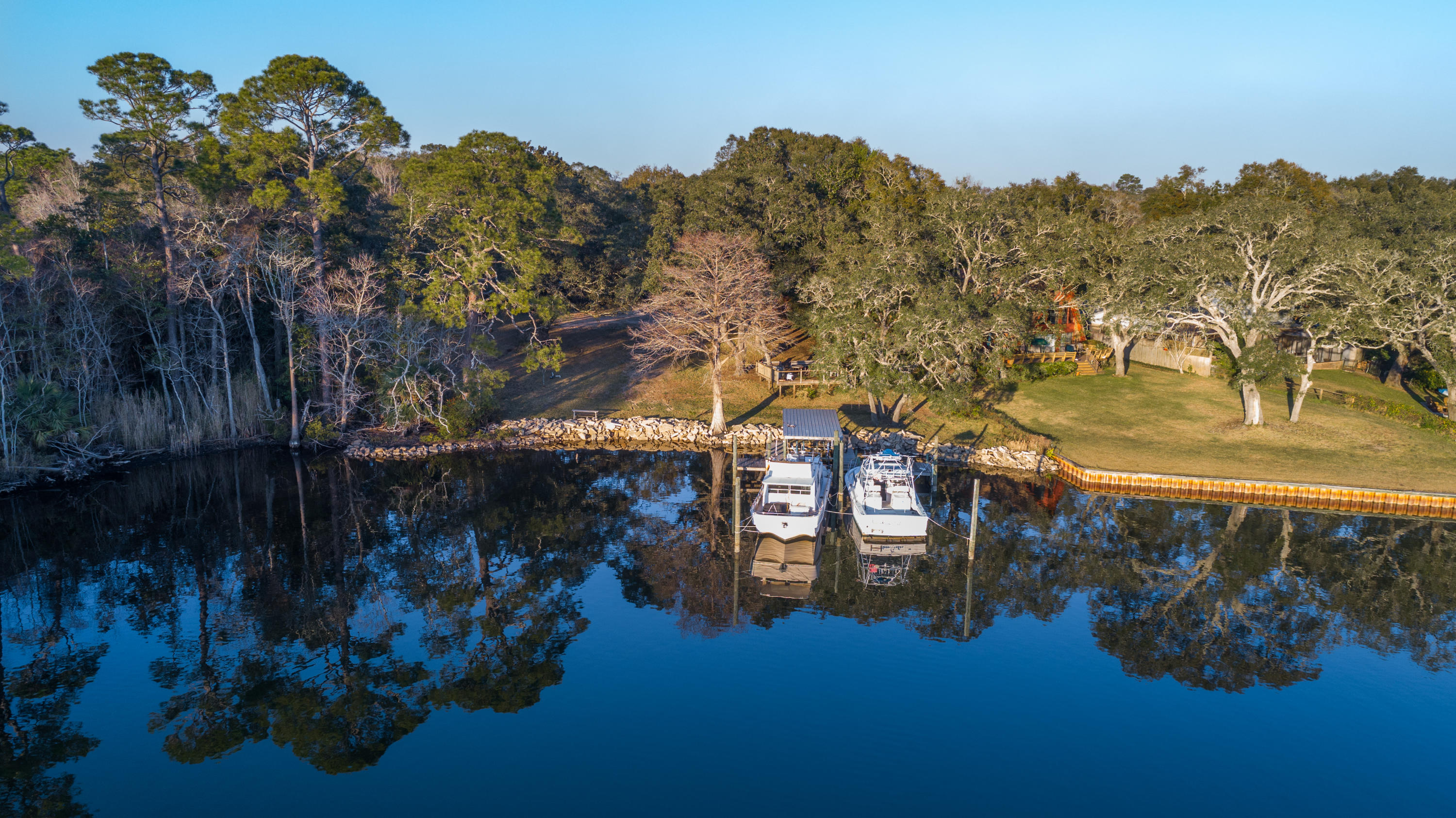 SPECTACULAR DOUBLE WATERFRONT PARCEL! 170 FEET OF DIRECT WATERFRONT ON TOM'S BAYOU with DIRECT access to the sparkling waters of the GULF OF MEXICO. This LARGE 1.08 ACRE property includes TWO build-able parcels with breathtaking waterfront views of Tom's Bayou. LAND IS CLEARED and READY FOR CONSTRUCTION. BEAUTIFULLY MAINTAINED DOCK will accommodate two or more large boats.  Perfect for an ESTATE sized property, a FAMILY COMPOUND with multiple buildings, or may be subdivided by a developer. This property has been meticulously maintained and cared for. Planning and design services are also available for this incredible building opportunity.