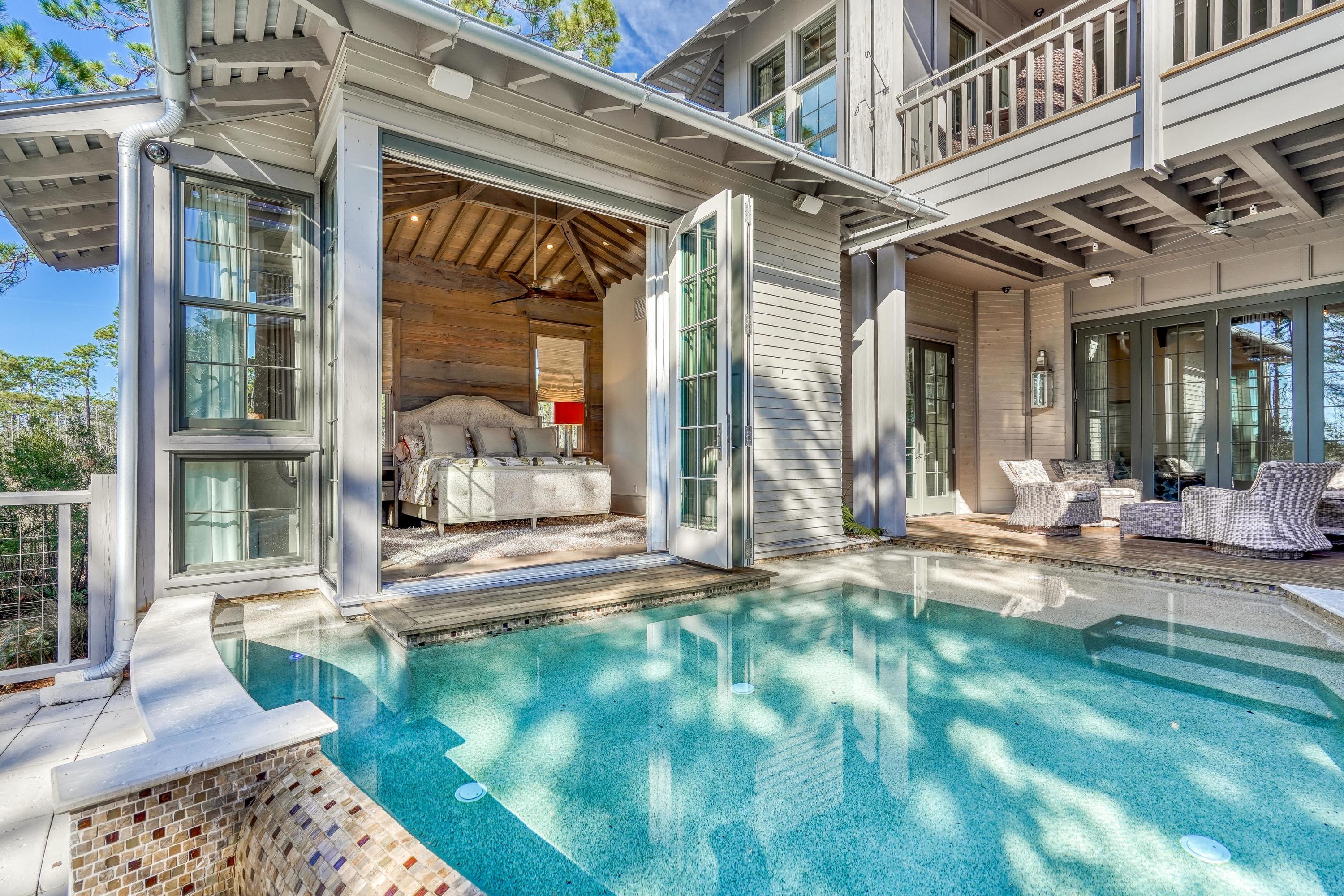 Sweeping, one-of-a-kind views of Western Lake, the Gulf of Mexico and Grayton Beach State Park define this masterpiece collaboration between architect Matt Savoie of Savoie Architects, builder John Brown of Gulfview Construction and designer Karen Waterfield of Sugar Beach Interiors. This 5BR/5.5BA lake front residence with private infinity pool is perfectly positioned to offer a peaceful sense of seclusion yet is nestled in the premier Vermilion Point district of the WaterColor Inn & Resort. Rustic meets 30A with truly unique and memorable interiors meticulously selected and sourced such as red & white oak wide plank reclaimed floors, walnut doors and honed granite countertops. This home is fully handicap accessible with an entry ramp and a commercial elevator that services 3 levels. The downstairs bedroom suite has a bathroom designed  for wheelchair access. At the heart if the home  find a stunning 
 under-lit spiral staircase with custom handrails and a suspended light fixture that illuminates all stories. Three living areas,one on each floor, overlook the lake and the forest with the views becoming more spectacular as you ascend. Retractable doors on the first two levels allow indoor and outdoor living spaces to seamlessly blend. Entertain with ease around the private pool with multiple seating areas, an outdoor fireplace, a covered summer kitchen and outdoor TV. The downstairs master suite is a true retreat with floor-to-ceiling windows and retractable doors overlooking the lake and pool, reclaimed wood ceilings and accent wall, direct access to the pool and an expansive master bathroom and closet area with a separate counter which has a private refrigerator. On the second level, find a living room that fully opens to a covered porch with retractable power screen and fireplaces both indoors and out. A united game room and office space provides comfortable areas to work and play while the dining area boasts incredible views. The gourmet open kitchen offers Wolf and Sub-Zero commercial appliances, custom cabinetry and a large center island with seating. The spacious one-bedroom carriage home with floor to ceiling windows which bring the State Forest into the space can be accessed from this level or can be locked out to have only outdoor entry. Two additional guest suites with ensuite bathrooms are located on the third level. The western facing tower room includes a cozy interior space complete with daybed perfect for reading and an outdoor seating area where the amazing lake and sunset vistas can truly be appreciated. An oversized garage provides ample space for storage of a GEM car that conveys with purchase, along with Kayaks and an abundance of beach toys. Custom furnishings and window treatments are also included.  Located on 499 aces in the renowned South Walton beaches, WaterColor was created with families in mind and offers the charm of small-town life. Exceptional community amenities include six beautiful swimming pools, a Gulf front beach club, nature trails, a Boathouse offering kayaking, canoeing and paddle boarding, a fitness center, outstanding tennis facility, Camp WaterColor for kids with lazy river and waterslide, parks and green spaces.