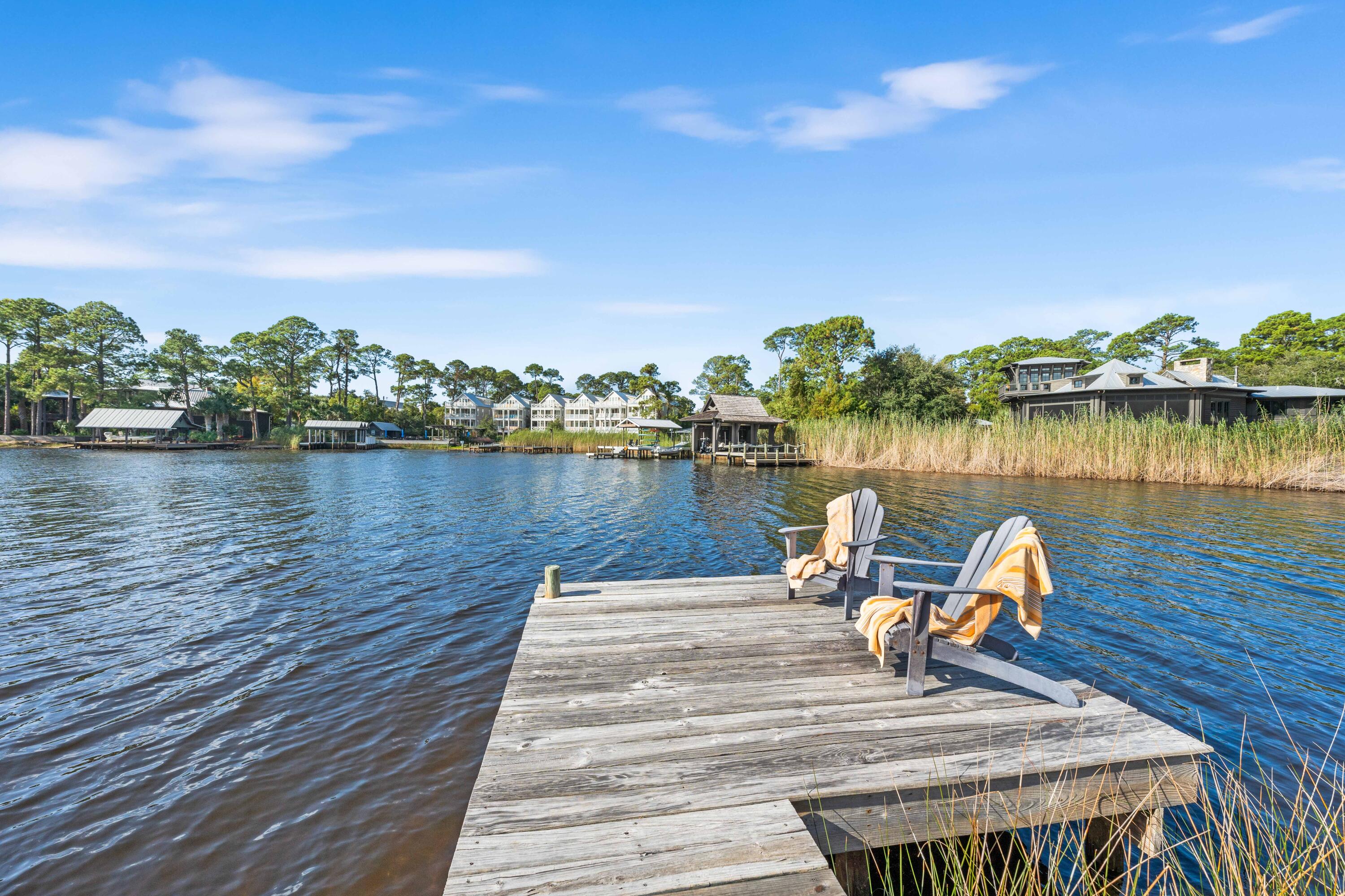 Welcome to your dream home in beautiful Grayton Beach! This serene waterfront property on Western Lake is a modern plantation-style getaway which draws its roots from the concrete block homes that once lined the beaches on 30A. Located in the desirable gated Lake Place neighborhood, it is just a short distance from the Gulf of Mexico. Leave your car at home and kayak, to Grayton Beaches or park your boat at the public dock in Grayton and party at the Red Bar. Surrounded by state land but minutes to easy access to Highway 98. 

The location is as good as it gets. This spacious 4-bd, 3-ba home is designed for relaxation and entertaining. As you enter, you'll be greeted by a contemporary maple staircase of steel and cables handrails that leads upstairs to a large living room featuring a va ulted ceiling of birch wood. In contrast painted plaster, and exposed concrete block create an untraditional beach house interior. The open-concept layout connects the living, dining, and kitchen areas, and is flooded with natural light from expansive windows.
The modern kitchen has many new appliances, and an island with granite countertop, and ample custom mahogany cabinetry, perfect for culinary enthusiasts and displaying your favorite China and art. Vibrant decor throughout reflects the family's love of bright colors and whimsical design, making this home a cheerful sanctuary.

Step outside to enjoy expansive views and your very own private access to Western Lake. The native landscaping and spacious second-story veranda, complete with a deep roof overhang, provide a well-shaded destination for relaxation. Whether you're hosting summer barbecues or enjoying a quiet morning coffee, outdoor spaces on both levels offer privacy and an idyllic setting to soak in the ambiance of northern Florida living.
When you are ready to venture out of the neighborhood, a dozen restaurants and multiple shops are within a short walking distance.  This is a unique opportunity to experience the best of coastal living in a property that embodies charm, elegance, and family warmth.

Don't miss out on this incredible opportunity! Schedule a viewing today and make this picturesque waterfront retreat your new sanctuary.