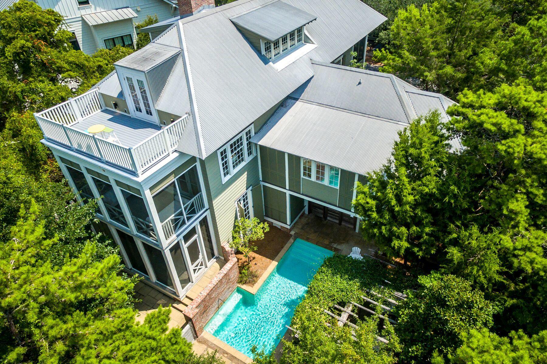 This spacious and sophisticated custom beach house with views of Western Lake in phase I of WaterColor offers contemporary design with outdoor living spaces that rivals a day at the beach. Built to classical scale, this 4,433 square foot Smart-home home highlights balance and proportion with large bedrooms, expansive porches and open living spaces that were made to gather. The shaded front porch offers cozy rockers that invite guests to relax, while the sliding barn doors carry you through to the generous yet private courtyard with a pergola and pool, set to the relaxing sounds of the fountain and created for enjoying the Florida outdoors. A large screened-in porch with built-in storage space and an open-air grilling area with two outdoor showers tucked away in the natural landscape complete the courtyard space. This elegant three-story home features five bedrooms and a bonus bunk room with coveted outdoor living on each level. Offering soaring ceilings, shiplap walls and a generous family room with a fireplace anchoring the main level, this one-of-a-kind home features expansive windows throughout that flood the space with natural light. Barrel-vaulted hallways lead to two spacious main floor suites, one with a well-lit, cosy reading nook. A large laundry room and a half bath on the main level are just a couple of the hidden treasures of this custom home. The expansive, open concept gathering space on the second level boasts a fireplace and a soaring 12-foot ceiling with beautiful cypress wood beams to define the space. A well-dressed, barrel-vaulted kitchen boasting Gaggenau and Sub-Zero appliances, two sets of custom designed doors hiding two large pantries, an espresso maker, a huge limestone center island with ample workspace, storage and expedient breakfast bar seating for five anchor the space. Off of the kitchen is a large screened-in porch that offers an expansive table with seating for eight for alfresco dining year-round. At the other end of the great room is a large dining room complete with a soaring detailed ceiling and a circular dining table offering seating for six. Another expansive screened-in sleeping porch boasting two cozy beds creates a perfect spot to spend the peaceful evenings. The luxurious master suite with an office space overlooking the courtyard, a large walk in closet, and a well-appointed spa-like bathroom retreat featuring dual vanities, a soaking tub, opportune Dacor towel warmers and a deluxe shower with a rainfall shower head can all be found tucked away behind french doors off of the great room. A convenient wet bar is also located on this level off of the living room with a coffee bar, ice maker and sink. The third floor offers an expansive guest suite wrapped in shiplap boasting a bonus bunk room, a large open terrace featuring glimpses of the lake and Gulf, and lots of bonus storage space. This one-of-a-kind, modern beach house with sleek lines and elegant finishes is a must see in the heart of WaterColor. Call to schedule your private showing today!