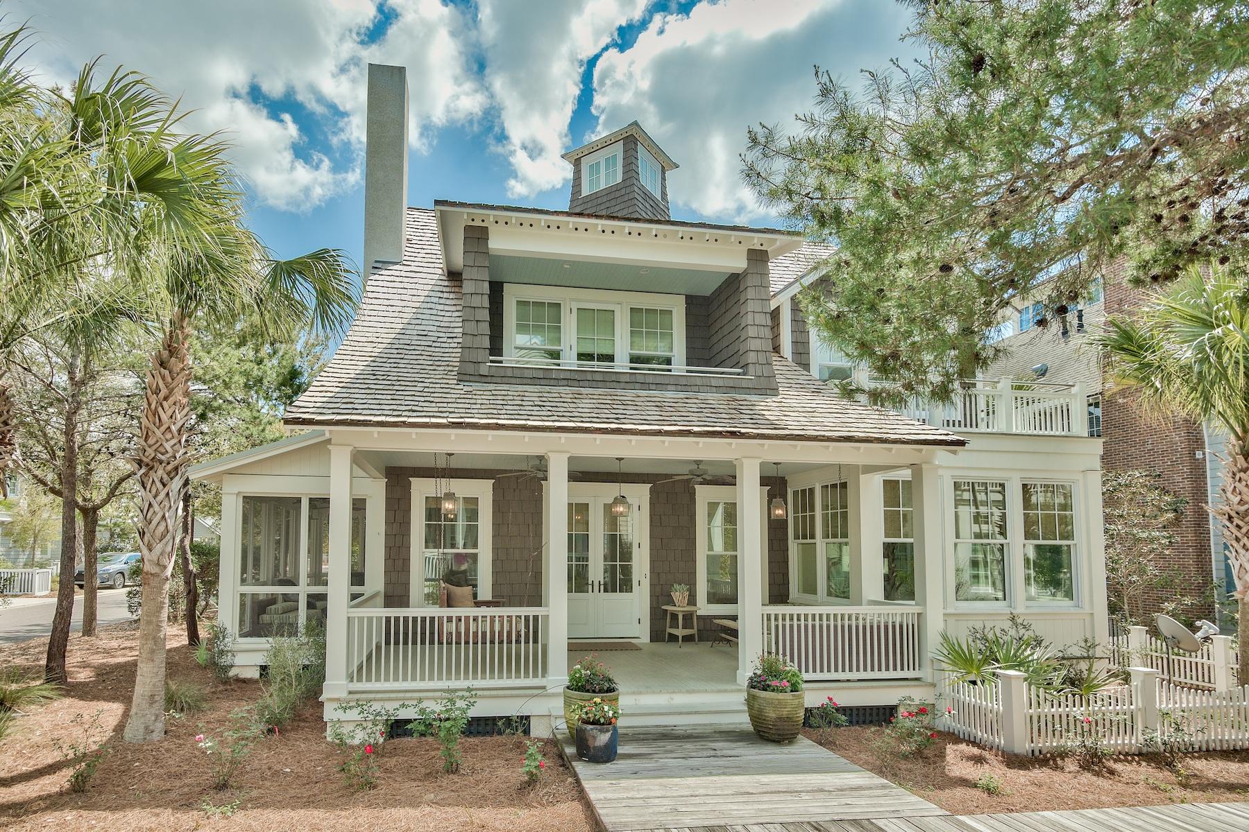 Situated on a large corner lot, meander onto the boardwalk in front, walk in the woods out back, and in under four minutes on foot, you can have your toes in the sand on the luscious pearl white sand beach. This wonderful home comfortably blends timeless sophistication with eternal simplicity. It's a splash of Nantucket tucked into a luxurious WaterSound setting. The front porch beckons one sit for a spell, and the open concept interior calls for fun times and magnificent entertaining. An elegant, contemporary kitchen and dining nook are flooded with natural daylight, with more dining space at the breakfast bar and dining table. A large gas range, double ovens, marble and granite counters, stainless steel appliances and a farmhouse sink are complemented with a butler's pantry for prep work at another farmhouse sink plus overflow storage. The living room flows seamlessly with copious windows, a gas fireplace and a wood ceiling with classy white beams. Hardwood floors, wood wall accents and finely crafted architectural details attest to quality in design, function and materials. Five bedrooms and bathrooms, plus a powder room, ensure sleep quarters for a crowd. Everything here evokes quality workmanship and makes this home a magical property for a Sunshine State lifestyle of wonder and comfort.The corner lot affords space for a private pool and carriage house with garage. Detailed plans available upon request. With strong rental bookings that convey, some decor may be different than shown in photos. Cedar shake roof was replaced in 2018 along with complete exterior painting. Photos were before roof and paint.