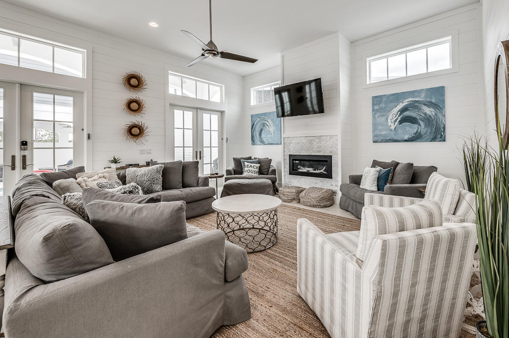 Built in 2019, this inviting beach retreat has all the marks of a quality residence: 12-foot ceilings with bright transom windows, travertine flooring, a beautiful gourmet kitchen with high-end stainless appliances, and private amenities. White shiplap walls in the main home provide a quintessential backdrop for the contemporary gas fireplace in the open-concept great room, while French doors lead out to a secluded courtyard with covered terrace. The private, heated pool provides a perfect space for leisurely afternoons and al fresco entertaining in all seasons, and there is plenty of space to further customize this outdoor oasis with a summer kitchen or fire pit. Five spacious suites are located in the main home with a luxurious master bedroom and spa on the first floor and four... ...additional suites on the second level, including a bunk room. A private hideaway for guests, the detached carriage house offers an additional bedroom, bathroom, and a fully-equipped kitchen over the garage. Perfectly suited as either a primary residence or rental property, this compound is just a short ride to the beautiful, white sand 30A beaches, easily accessible with the included golf cart. Offered furnished and rental ready.