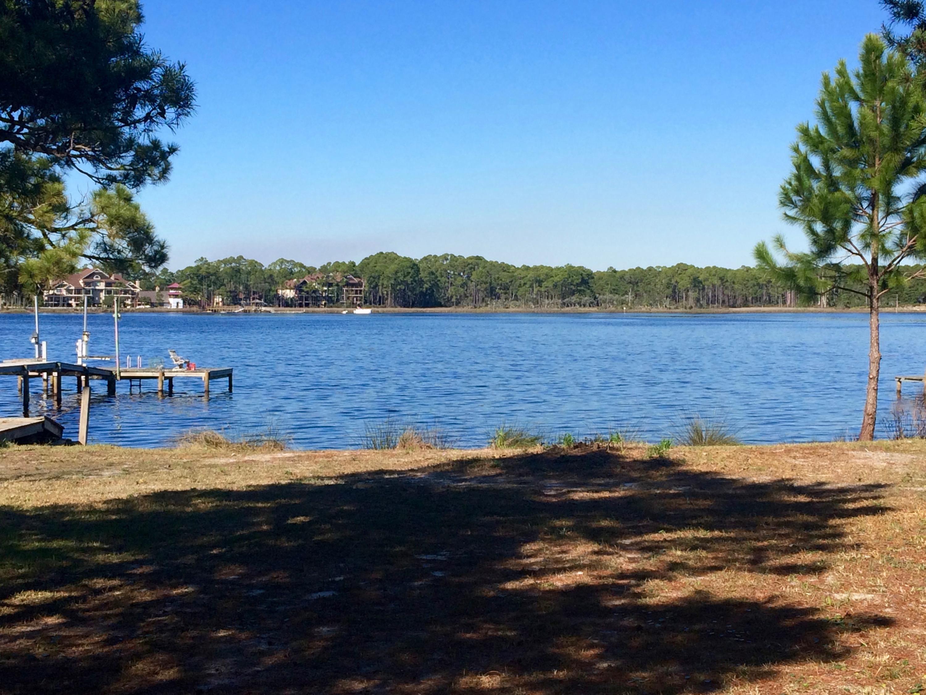 Just Reduced! Beautiful, secluded, private lot on Lake Powell, the largest Coastal Dune Lake. Because it's located in Bay County this lot is not subject to the Coastal Dune Lake restrictions of Walton County. This unique lake offers both salt water and fresh water fishing, created by the opening and closing of the outfall to the gulf. Enjoy swimming, fishing, boating, skiing, canoeing, crabbing and other water activities. The property has an expired dock permit, easy to renew, with a design that allows for both motorized craft and canoes/kayaks. Access to the gulf is about a 4-5 minute boat ride across the lake. The lot provides lots of privacy, starting with a 160 foot private drive, partially paver and landscaped, which opens into the lot, 180 feet long with 75 feet on the water. This extra large lot provides for a large custom home, with 3 car garage and carriage house, for visitors or used for rental income. Even with the home and carriage house there's plenty of room for a pool with jacuzzi option. With the proper design, the housing and carriage house allow for multiple decks, all with lake views. This is a one of a kind location to build a traffic home on the water, but with the seclusion and privacy unparalleled on any lot located on Lake Powell.