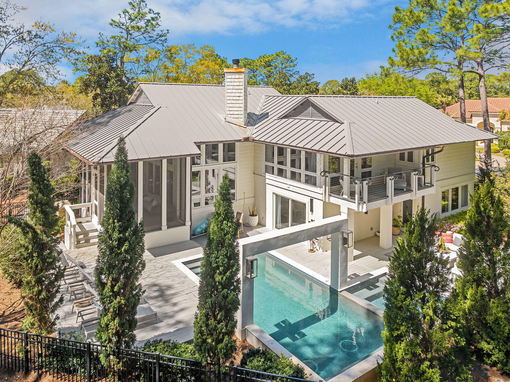 Tucked in the pines in the exclusive enclave of Burnt Pine is where you find this 2671 sf 3BR/3.5BA home. Refreshingly unique in design for the area, the simplicity of the exterior reveals a touch of modern esthetic. As you approach the entry and the fabulous oversized, custom front door with it's sleek polished nickel hardware, it is apparent you have arrived somewhere stylish. As you enter, the ''lightness'' of your surroundings is like a breath of fresh air. No garish colored walls, heavy moldings or overly ornateness here...only a soothing, sophisticated backdrop of seamless neutral color, luxurious white Peacock Paver floors and clean, uncluttered lines. Split level in design, the main living area beckons you up the stunning white stone staircase with it's gleaming elegant metal handrail, but first, stop to explore the two bedrooms located at entry level. Each bedroom has generous amounts of light and elegant private baths with Carrara marble vanities, sleek polished nickel cabinet hardware, faucets and light fixtures, and large glass-enclosed stacked white subway tile showers. Back in the entry, the hallway leads past an elegant half bath to the attached two car garage. Extra storage space is tucked neatly under the stairs. Up the half flight of steps is the light-filled main living area. An abundance of floor to ceiling windows expands the interior to the beautiful, forested out-of-doors. Perfect for entertaining and also for keeping a family close, the layout flows perfectly between living, dining and kitchen. The 14 ft ceilings showcase the dramatic limestone gas fireplace. The kitchen is absolutely stunning; uncluttered, streamlined and elegant, and outfitted with stainless Jenn Air appliances. Glistening marble tops the island and the countertop that continues high up the backsplash to gracefully accent the open shelving. Upper cabinetry and pantry is neatly disguised along a sleek, grooved wood wall, revealed only by stainless flush mount ring-pull hardware. So well crafted, you might miss one pair of doors leading to an adjacent room, ideal for a kids lounge area, bunk room home office. Close the doors and you might forget it is there. Beside the kitchen is the dining area surrounded by windows and opening to a large screened porch and deck. Up a second half level is where you find the master suite. Luxurious wool carpeted bedroom with vaulted wood ceiling, two walls of windows and one that opens to a private balcony with stainless cabled railing. The beautifully forested backyard conceals any neighbors nearby. Enter the elegant master bath to find dual marble topped, metal based vanities with top quality polished nickel fixtures and a generously proportioned walk-in shower with standing glass panel, ceiling mounted rain head faucet with wall-mount handheld. Off the master bath is one of two oversized closets located on this level. As you exit the master suite, pause to admire from above this beautiful home as it is opens to your view. Take note of the elegant details you have observed, like the high quality recessed LED lighting throughout, fixtures, faucets, marble, cabinetry, flooring, and even the sophisticated metal trimmed vanity mirrors in all baths. There are also the valuable details not so readily apparent, like a Rinnai tankless water heater and a whole house natural gas generator. You owe it to yourself to experience this uniquely modern esthetic in exclusive Burnt Pine.