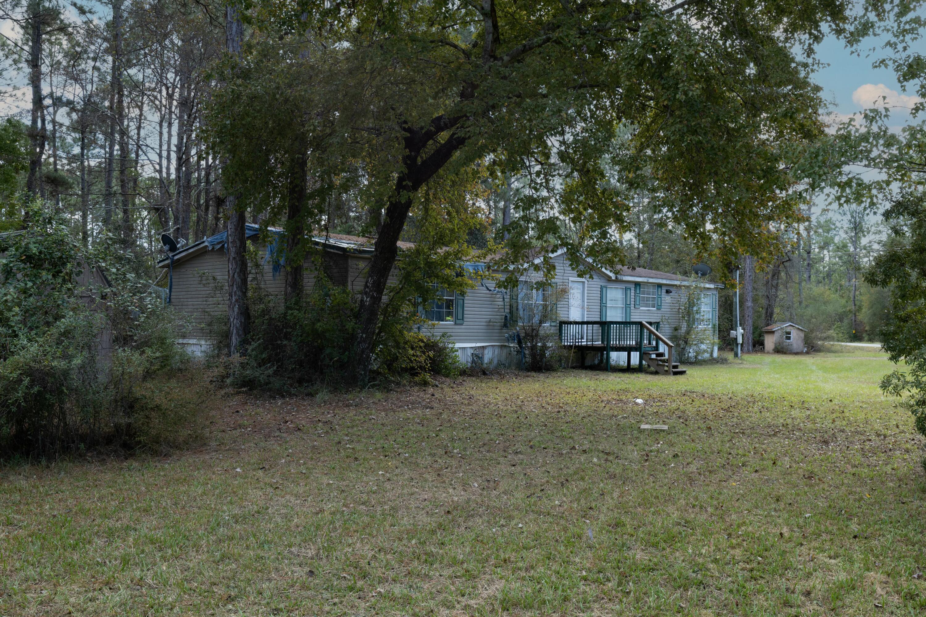 This beautifully wooded lot of approx .98 acres parcel is located at the corner of LaGrange and Mullet Rd in Freeport at corner of (2) paved roads There is an existing double wide mobile home on the property which is considered of No Value.  NO HOA or RESTRICTIONS!!! 

The existing old mobile home needs to be removed. It is considered not livable and the seller has taken the cost of removal under consideration in pricing.  Approx. verbal quote of removal is $10,500.00 from local contractor to include porch stoops.  To the seller's knowledge all existing utilities still exist on the property.  Type of utilities are currently being confirmed.   

This property consist of (2) lots.  We have not been able to determine if county would allow each of the lots to be built upon separately due to the unrecorded plat map.  The lots must be determined to be lots of records with both Walton County and with Health Department.  

Zoned Rural Village. NO FLOOD insurance required and No Wetlands per GIS mapping.  Please note the property appraiser lines do not appear to be accurate.  Buyer survey is highly recommended to confirm property lines. It's our understanding that the property does not cross LaGrange Road. However, a survey will need to be completed to confirm the property lines. 

Easy access to Hwy 331 bridge with NO TOLLS. Conveniently located approx. 8 miles from Hwy 98 with easy access between Destin and Panama City Beach.  

Spend your weekends enjoying the endless array of outdoor activities and water sports, some including (fresh or salt water) fishing and convenient parks for hiking and exploring. Plenty of space for all your fun recreational toys! Multiple public boat ramps nearby!

Only 5 minutes to Publix grocery store and approximately 20 minutes from some of the most beautiful white sandy beaches on Florida's Emerald Gulf Coast. Take advantage of the close proximity to fabulous shopping and restaurants on 30A, and the World-famous Crab Island.

All Information and dimensions to be verified by the buyer. The buyer is responsible to verify county and/or local resources to ensure they can do what they want to with the property.  Buyer responsible to verify existence of all utilities, if any.