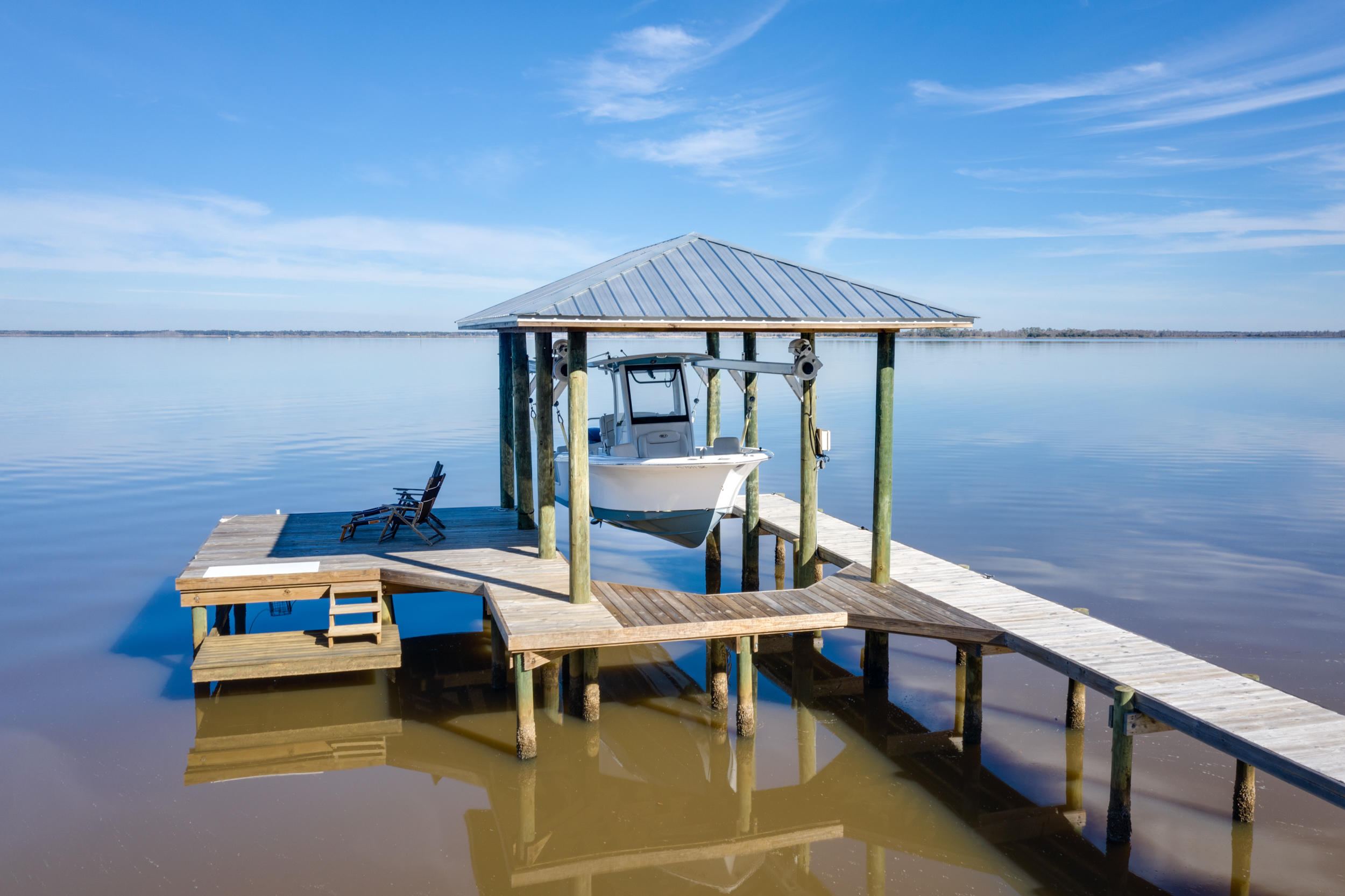Completely renovated in 2019, this Geoff Chick redesigned bayfront modern farmhouse is full of character and charm and 100 feet on the Choctawhatchee Bay. Located in Point Washington on a quiet street with beautiful oak trees and gorgeous sunrises and sunsets, this home features a large heated pool and spa, covered boat lift with dock and swim/paddle platform, outdoor covered porch and large lush lawn. With Bevelo gas lanterns, painted white brick and hardiboard siding and shutters, this 3400 sq ft home has a great layout of 4 bedrooms and 4 full baths and living area (living room, den, dining room, kitchen and study) all located on the main floor. There is even a flex bonus room upstairs that can be used as a workout room, playroom or office. The foyer opens to the large great room the perfect open living concept with tongue and groove cathedral ceiling, giant wood beams and a painted stucco gas fireplace. Natural light floods through the house with the new Kolbe Forgent Series casement windows and Neuma fiberglass doors, both with hurricane impact glass. The master bedroom has panoramic views of the water and vaulted ceilings. Other features include white quartz countertops in kitchen, laundry and all 4 baths; recessed LED lighting throughout home; mudroom with storage lockers; shiplap walls in all baths and study and laundry room with sink sliding barn door.  Flooring consists of porcelain wood plank tiles throughout, painted wood floors in two bedrooms and marble and ceramic tiles in baths. Appliances included are the duel fuel Ilve free-standing range, Scotman Brilliance Nugget ice maker, Kitchen Aid counter depth refrigerator, Sharp microwave drawer, Frigidaire dishwasher and Whirlpool Duet washer/dryer. Buyer to verify all measurements and important information.