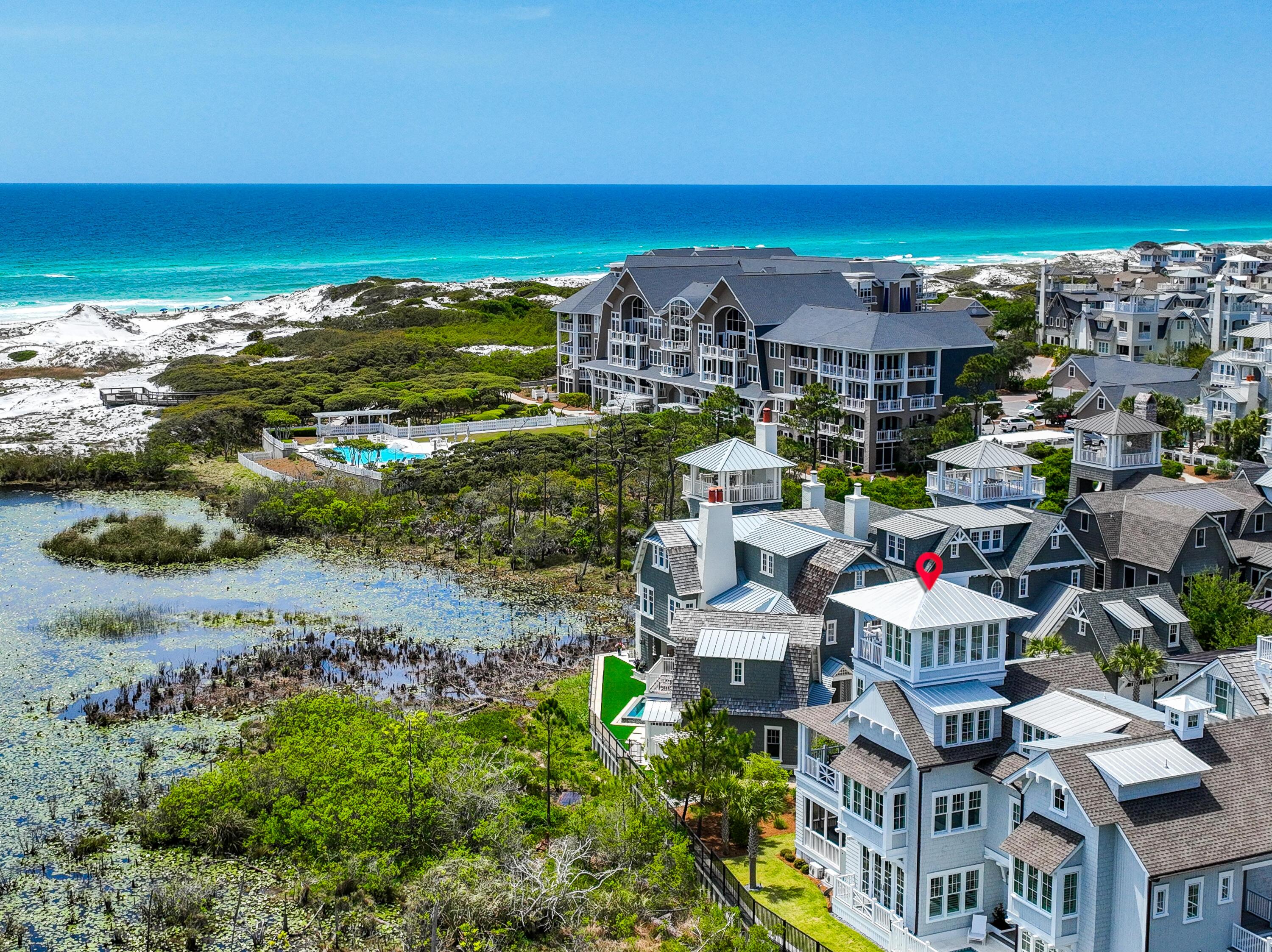 Nestled in the desirable Gulf front community of WaterSound Beach, this breathtaking home is situated on a sizable lot at the end of Compass Point Way. As you enter the home, you are welcomed by a large screened porch with a fireplace. The gulfs soothing waves can be heard creating a calming ambiance ideal for enjoying a glass of your favorite wine from your private wine room. Expand your entertainment space by sliding open the wall between the porch and main living area. Step through the front door to the expansive and open living area flooded with light from the wall of windows complete with a gorgeous gas fireplace and a charming dining area perfect for hosting guests or a quiet evening at home. Adjacent to living room, you'll find the gourmet kitchen including the Wolf and Subzero stainless steel appliances, dual icemakers, a wine fridge, wet bar and an oversized island for entertaining. Step out to enjoy outdoor living at its finest with a heated dipping pool and fenced yard. The home offers six bedrooms each with spa quality private baths.. The spectacular second floor master suite is complete with a large sitting area and expansive views of the Gulf. Offering a cozy and special space for guests, the carriage house lives comfortably with a bedroom, bathroom, sitting area and wet bar complete with a deck providing for a private and relaxing retreat. Guests may take in various views from the multiple covered porches. Enjoy your morning coffee with a side of sea breeze from the home's peaceful tower overlooking a pond, the Beach Club and the Gulf of Mexico. Additional amenities of the home include an elevator servicing all three levels of the home, a one car garage with golf cart storage and a full house generator. WaterSound Beach offers homeowners the finest in luxury living at the beach. Enjoy an incredible Beach Club with a poolside café, four pools, a dock access to Camp Creek Lake, Puttering Park, a state-of-the-art fitness center with workout rooms, conditioning and massage therapy, a spa and salon and a series of paths, boardwalks and bridges over the iconic sand dunes of WaterSound leading to the Gulf of Mexico.