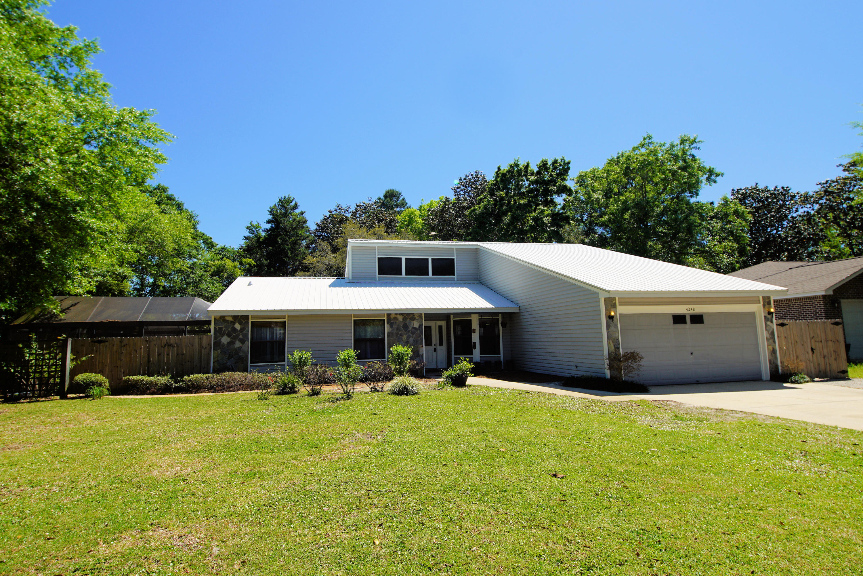 Beautiful four bedroom home with a pool, updated kitchen & metal roof in Bluewater. Lanai covered saltwater pool & spa with herringbone pattern pavered deck is the perfect spot for entertaining. Large sun room, plenty of windows & natural light, leads to the pool & is accessible from the living room & master bedroom. This great backyard is the quintessential location for roasting s'mores while sitting on huge logs surrounding the fire pit. There is plenty of room to add a garden, playground, sandbox, trampoline, tree house, or add a deck. Great flowing split bedroom floor plan with formal dining room, living room with vaulted ceilings, & renovated kitchen containing new cabinets, tile back splash, quartz counters, stainless appliances & a Butcher Block Island with pot rack. The whole house, other than the master bed & master bath, has been repainted with washable paint which is terrific for those with small children.  Large storage shed in the backyard.  Buyer to verify all dimensions.