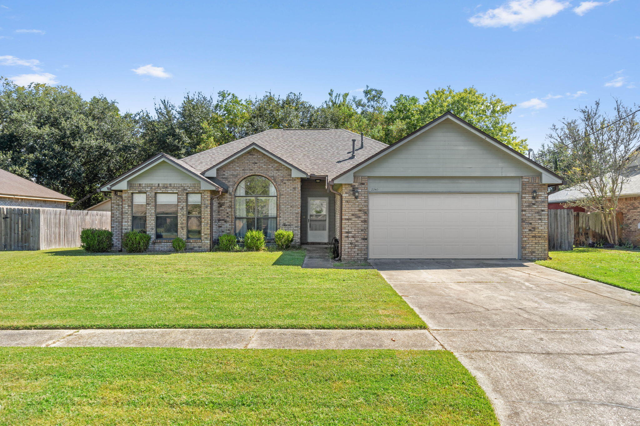 Located in east Navarre on a dead end cul-de-sac road you're going to love this updated gem in Fox Den! This absolutely charming all brick 3 bedroom, 2 bathroom home is around the corner from Walmart, only 3 miles from Navarre Beach, and a short commute to Hurlburt Field. Have peace of mind with a brand new roof (installed April 2024), a 2021 HVAC system, and a 2018 water heater. You'll also love recent seller updates like hardwood flooring throughout and a fully renovated kitchen featuring new cabinetry, granite countertops, new flooring, etc! There is a soaring 14 foot cathedral ceiling in the dining area and 10 foot ceiling in the living room complete with a lovely brick fireplace with stained wood mantle. Enjoy unique touches like arched windows allowing for natural light, custom  plant ledges between the living room and dining room, and a built in bookcase. The owner's suite is a retreat with a spacious bedroom with vaulted ceiling and an en suite with an oversized walk-in tiled shower, a walk-in closet, and double vanities. The split floor plan features two nice sized guest bedrooms on the other side of the house with ample closet space and a another full bathroom, as well as an interior laundry space. Outside appreciate seller updates like gutters, and enjoy a fully fenced in backyard with a wooded view. Enjoy this warm, distinctive, and custom feel - welcome home!