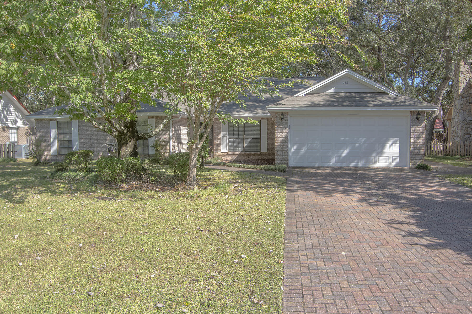 Located on desirable Dominica Circle, welcome to a renovated home with a private pool in Bluewater Bay. This brick 3-bedroom 2.5-bath home offers an additional flex room. Walking inside you are greeted by an open floor plan, a brick fireplace, and views of the backyard. The spacious master bedroom has an en suite bath with a walk-in shower and custom tilework. Comfort is key in this Bluewater Bay home. Plush new carpet in the bedrooms, luxury vinyl plank flooring throughout the main living areas, and light tile in the bathrooms. Situated on a 0.29 acre lot, mature oak trees and lush landscaping create an outdoor oasis. Enjoy a fenced-in backyard and a natural gas heated pool. Outside you have a covered patio, large paved entertaining area, and two storage sheds. Renovated in 2020, the roof and plumbing were replaced, the kitchen was renovated, along with the bathrooms, flooring, paint, vanities, lighting, and ceiling fans. Bluewater Bay in Niceville is abundant with amenities such as a marina, golf course, tennis courts, walking trails, and playgrounds. Reach out to your agent today to learn more!