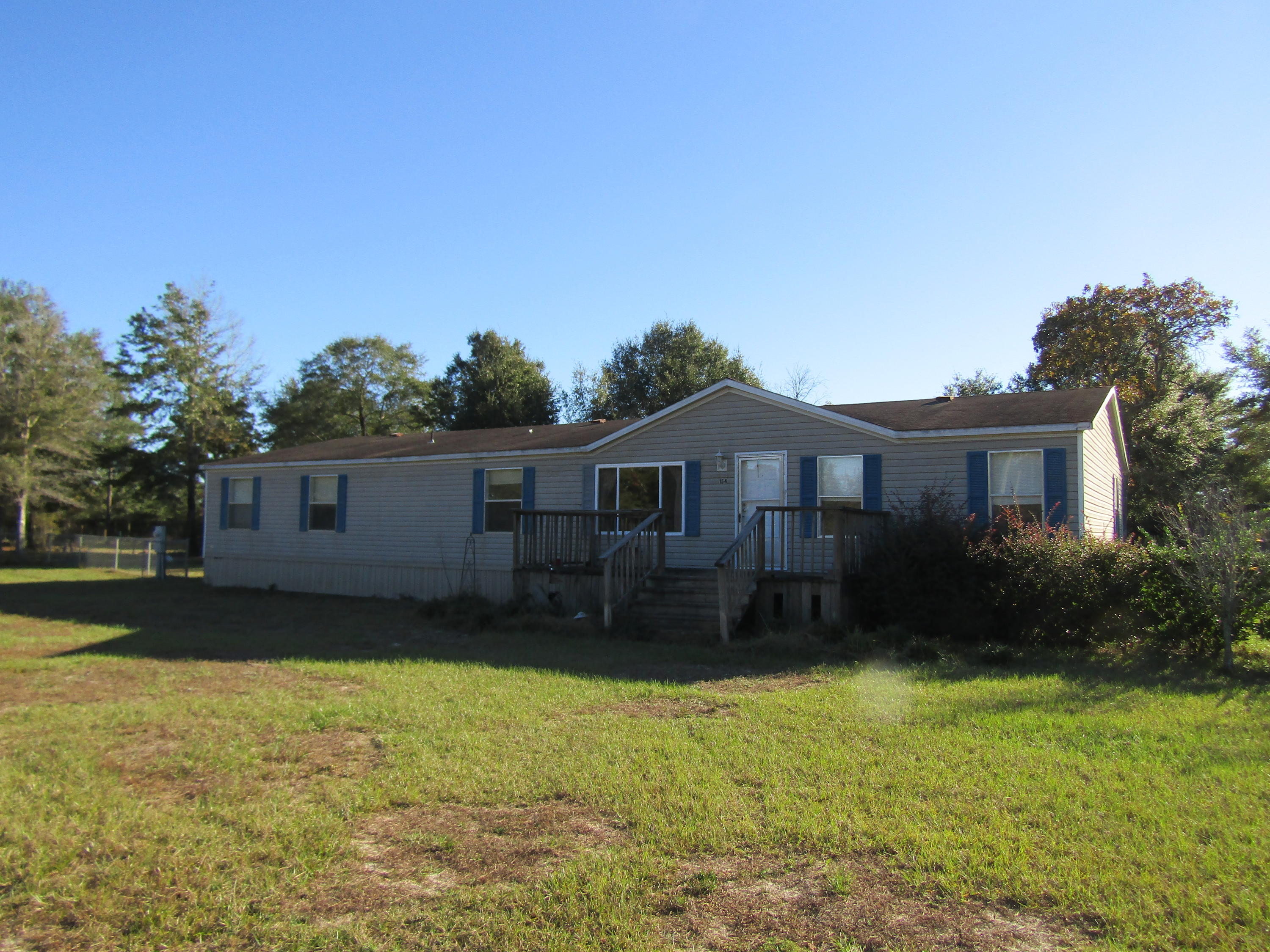 Super-size home on 1 acre with detached garage/workshop building with metal trusses and metal roof, concrete floor.  This home is a corner location with mostly chain link fencing.  Has covered back porch and yard pens for chickens, dogs or other pets....and struture that could be used for a dog house or chicken house.  Large 2100 s.f. home with 4 bedrooms, 2 baths, office, family room and living room.  Call today.