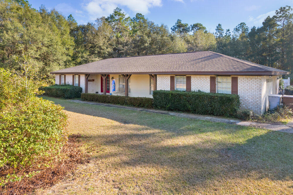 The home has so much! This well-maintained, ONE-owner, ENCLOSED POOL home is on 3 acres. There is fenced side yard for pets. On the property is a 50'x30' Detached insulated Building with 4 windows,power,lights, and a 12' door that easily accommodates an RV or large boat. A gravel parking pad w/ oversized electric hookup is just beside it. Hurricane shutters & a 15,000 watt Generac generator are included with the home. A Husqvarna zero-turn-lawn mower also conveys to keep the lawn cut.  The two-car garage includes two bonus rooms - one with a window AC. The washer and dryer in the inside laundry are included.
With the peace of the country, this home is convenient to everything you need; just six min. (3.6 mi.) to the Publix being developed on Dogwood and 13 min. (7.4 mi) to NAS Whiting