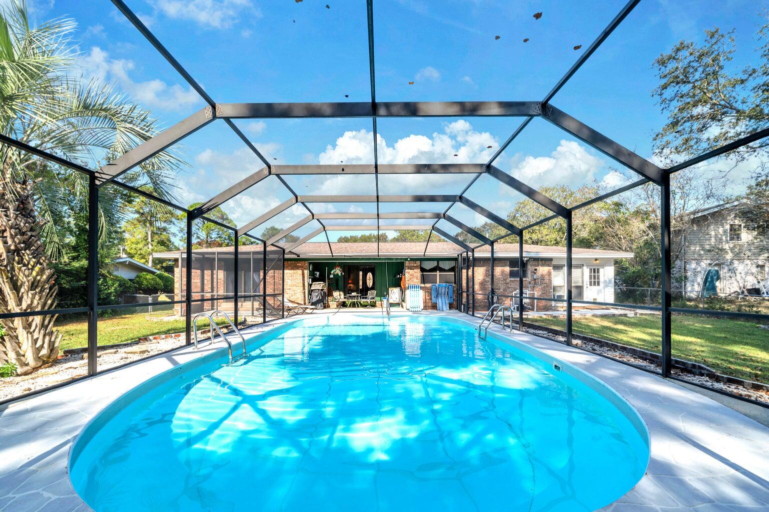 Home has been rewired with copper wiring for the new buyer's insurance.  Large Screened in POOL!  Your entrance into your home is a brick courtyard with a double rod iron gate.  As you open your double doors to enter you see your screened in-ground pool and lanai.  As you walk in straight ahead is your living area with sliding glass doors to your pool.  Leave those open-your pool is screened.  To the left of your living area is your formal dining room.  That opens up to your kitchen.  If you enter your home and take a left, instead of going to the living, you go into your family room that has a fireplace and Pergo floors it is open to the dining and kitchen.  The kitchen has tons of newer cabinet and counter tops.  French doors separate the family room from the Florida room.