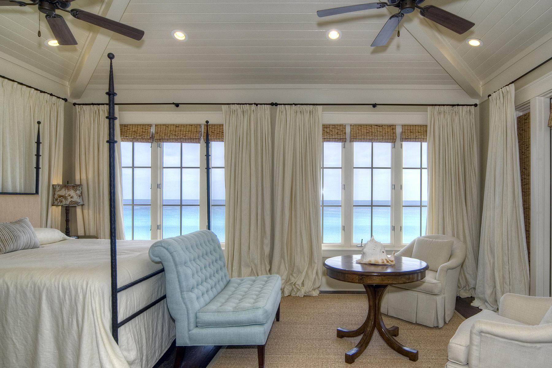 Exclusively situated in The Retreat, this five-bedroom home boasts an enviable gulf front location. Harmonious interior design by Susan Massey of Bohlert Massey Interiors, provides a comfortable atmosphere of upscale luxury to encourage a sense of relaxed beachfront living at its highest level. Spread over three floors, all served by elevator and hardwood staircase, this gracious home has the principal living areas on the second floor to take full advantage of gulf views. The wood beams and paneled ceiling in the living room provide a cozy atmosphere enhanced by an attractive gas fireplace and fully-fitted wet bar. Dual aspect French doors lead out to the screened porch with beachfront views on one side and a covered balcony overlooking the front courtyard on the other. The well-planned first floor includes two spacious guest suites each with their own private bath and access onto the rear covered porch. The versatile space in the self-contained west guest suite would be equally suited to use as a den. The third floor is dedicated to the spacious master suite incorporating twin walk-in closets and master bath with double vanity and well-placed bubble therapy soaking tub. It shares sparkling gulf views with the master bedroom, which includes a quiet sitting area with French doors opening onto the upper sun deck.