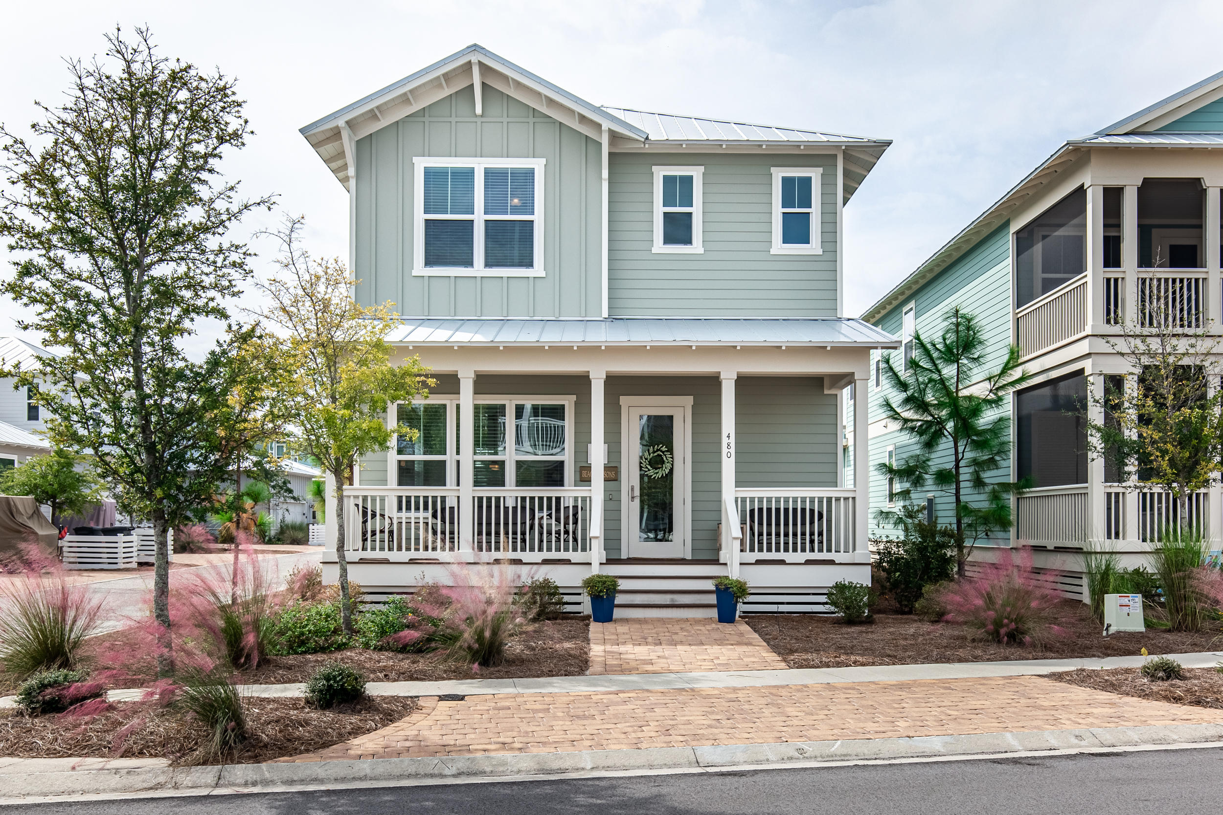 LOWEST priced 3 bedroom in NatureWalk! Be near all the fun in Seaside & Watercolor but own for a fraction of the price! This home won't last long! Lily Lane beach trail allows you to bike to the beach in 5 minutes. This 3 bedroom, 2 -1/2 bath home include a hard to find 2 CAR GARAGE and 2 covered porches AND is offered fully furnished. Everything is light, bright and beachy. Upgrades throughout include wood floors, ship lap, gorgeous white beams, Carrera countertops, shaker cabinets and more! 1st floor is wide open and plenty spacious for the whole crew. Upstairs you'll find 3 bedrooms- including master suite with double closets. One closet is currently furnished as a fun little bunk room for the little ones. Outdoor shower and gas line run to back porch. Corner homesite with room for a small fence for your furry friend. Also, plenty of room for parking in the pavered driveway behind home.  Rental Projections are $48,000.  Resort style amenities are just around the corner- The Gathering Place is at the heart of the community with beach entry pool, hot tub, heated lap pool, kiddie pool, grills, firepits, and tot lot. Also included is convenient seasonal beach shuttle, fitness stations, trails throughout community, and seasonal security. A few doors down from 480 Flatwoods is a sports court and swing set, as well as pond to fish in!